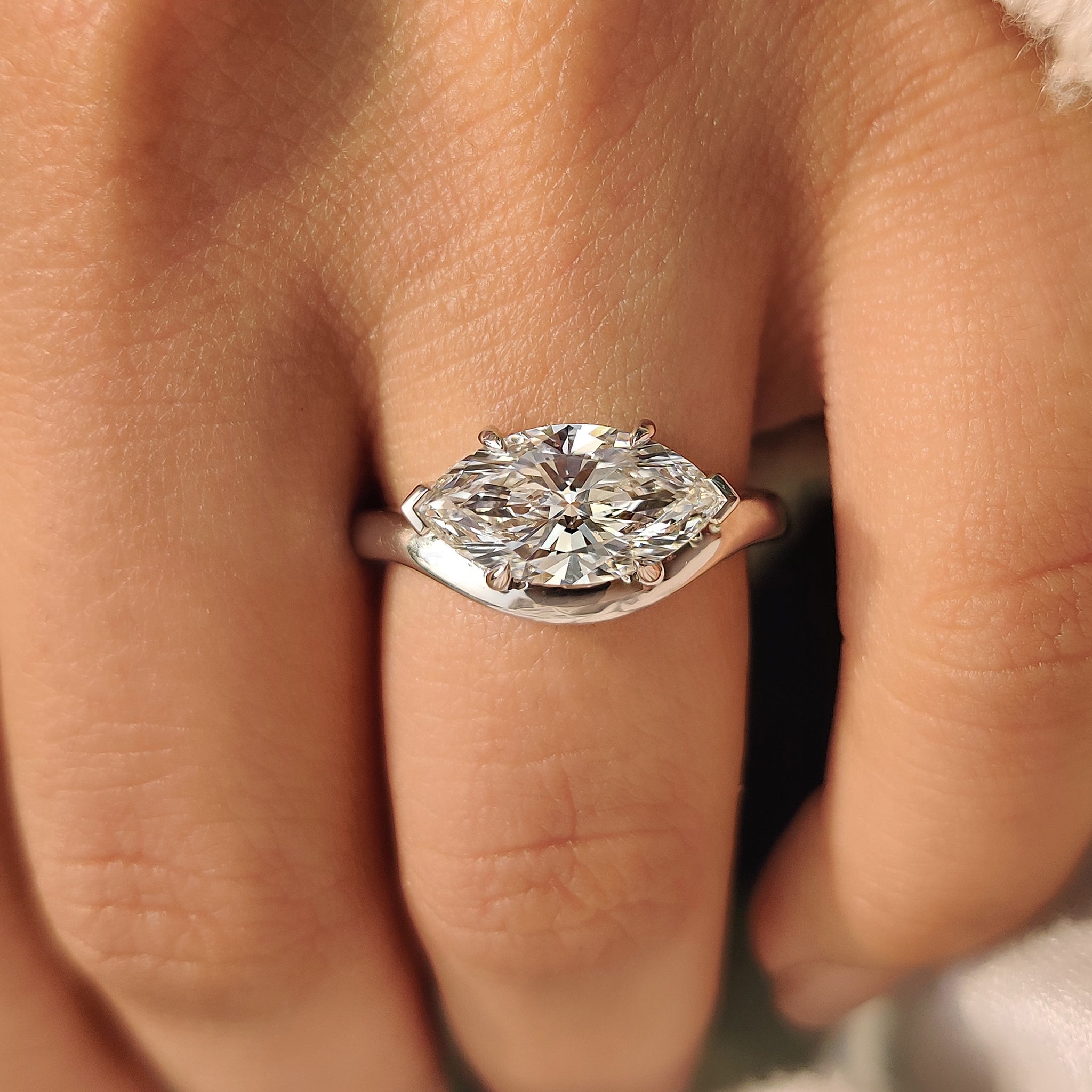 Solitaire marquise diamond engagement ring with four claw prongs
