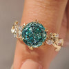 Portuguese cut cyan blue moissanite ring with leaf details.
