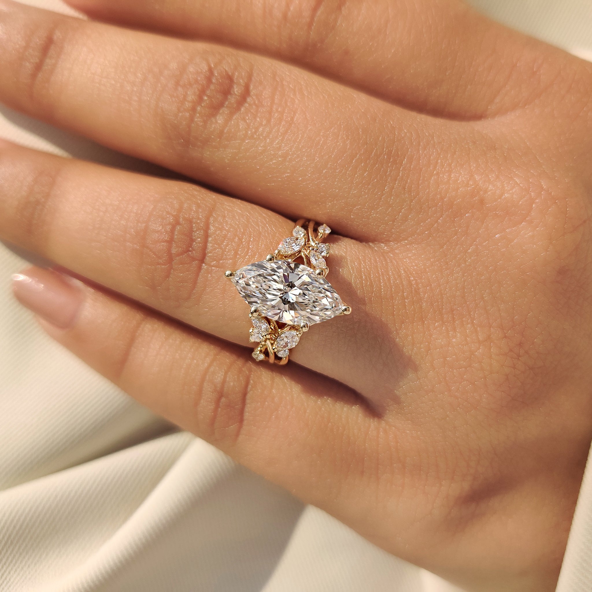 Nature inspired marquise diamond ring with round side accents.
