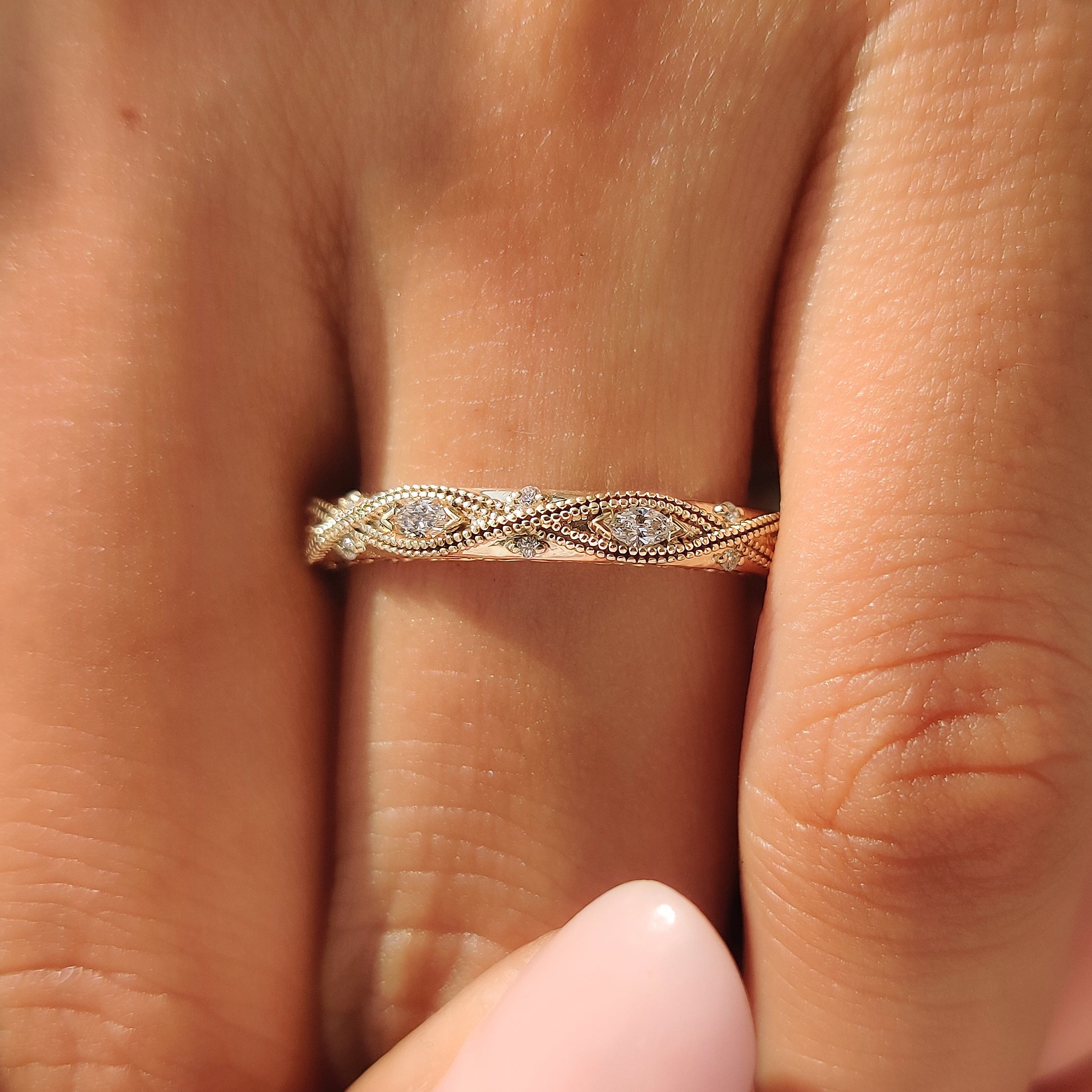 Handmade diamond wedding band with decorative stone settings.
