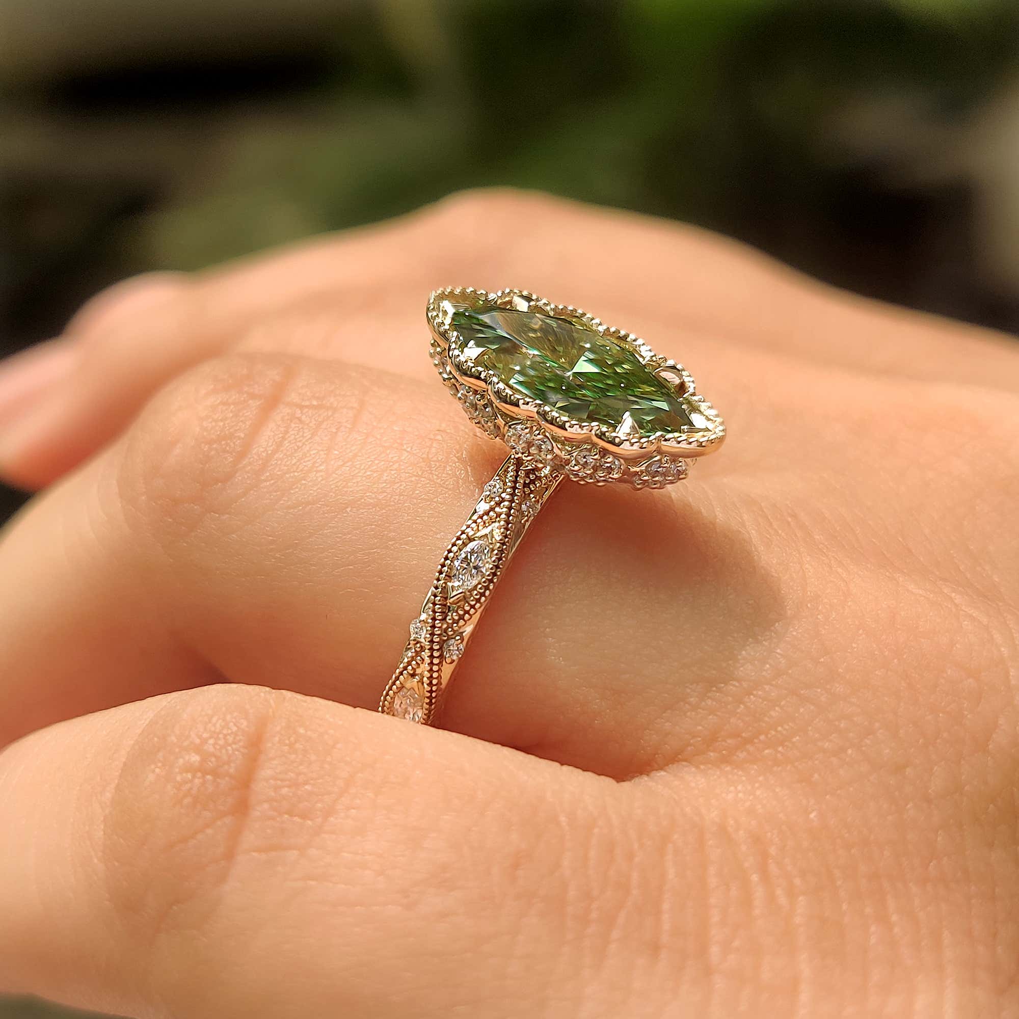 Yellow gold ring with green marquise cut diamond.
