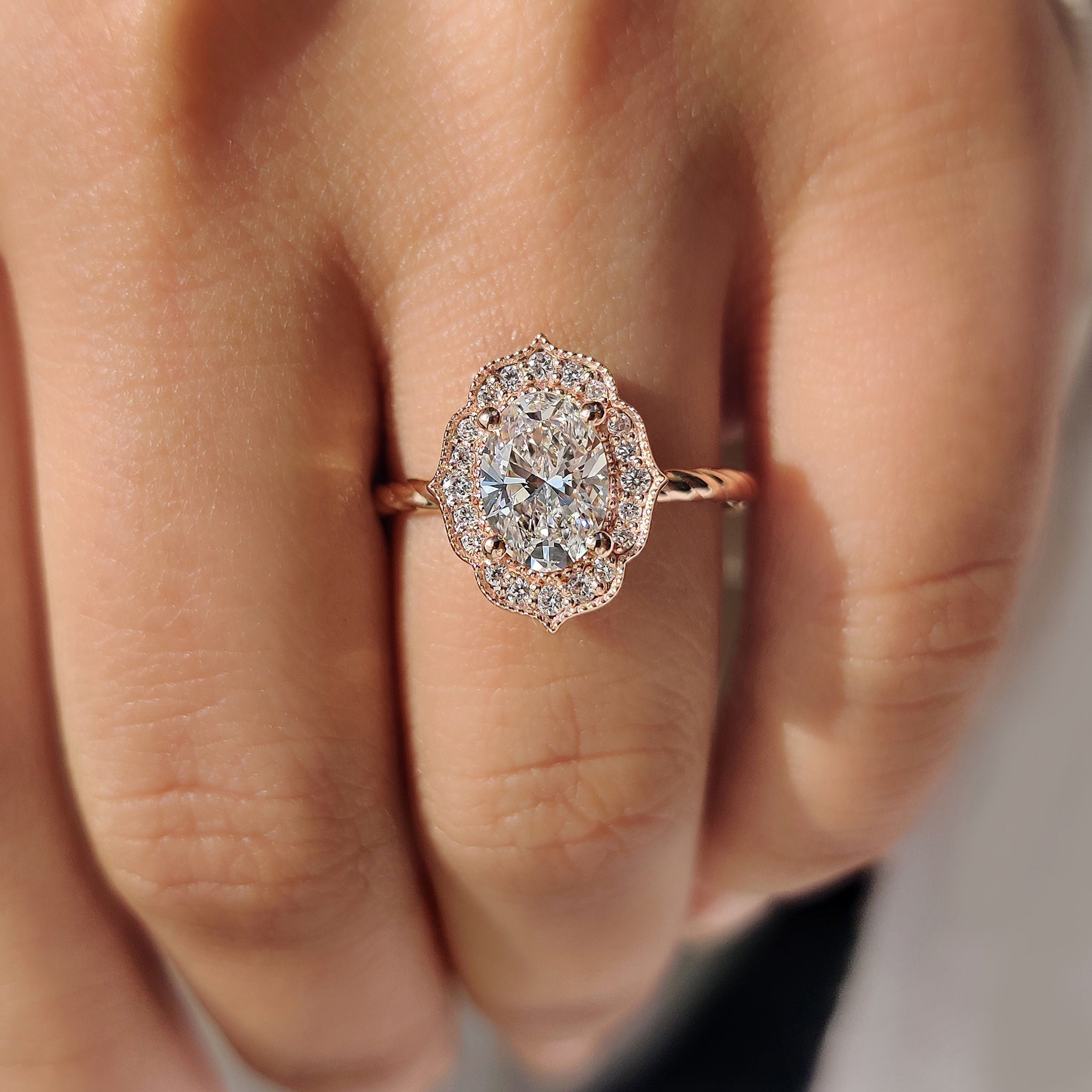 Oval engagement ring with round cut halo and twisted band
