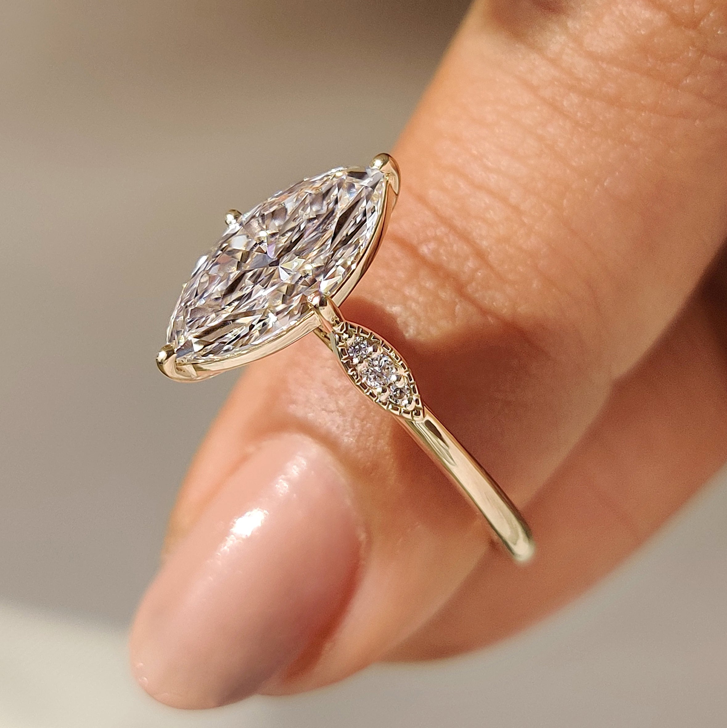 Marquise ring with compass prongs and milgrain detailing edge.
