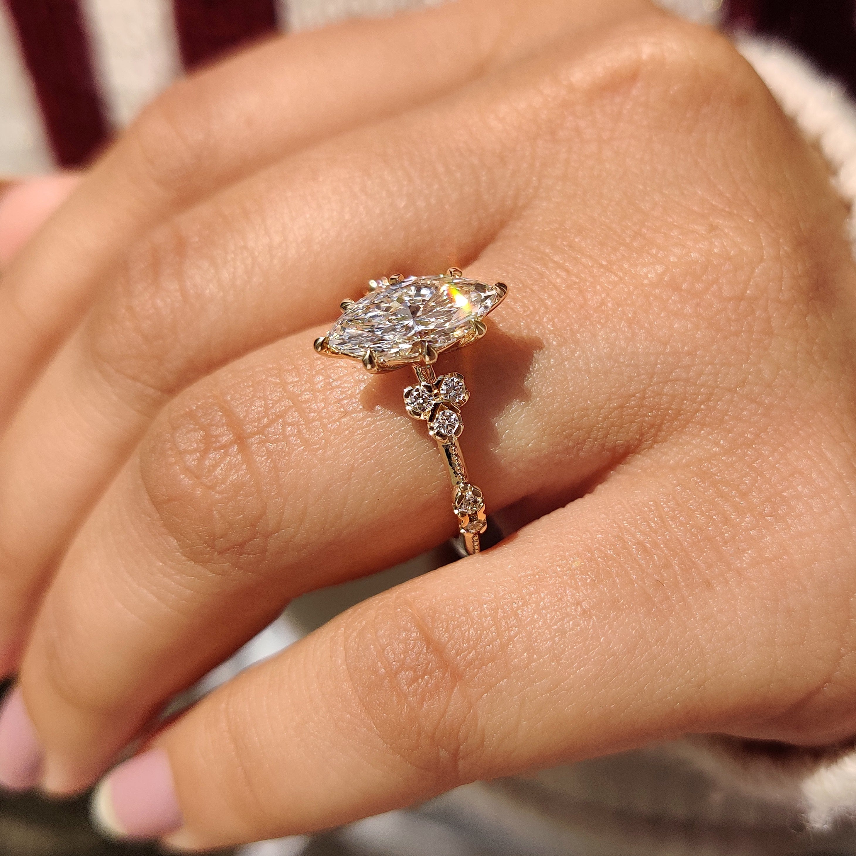 Lab grown marquise diamond ring with eight claw prongs.
