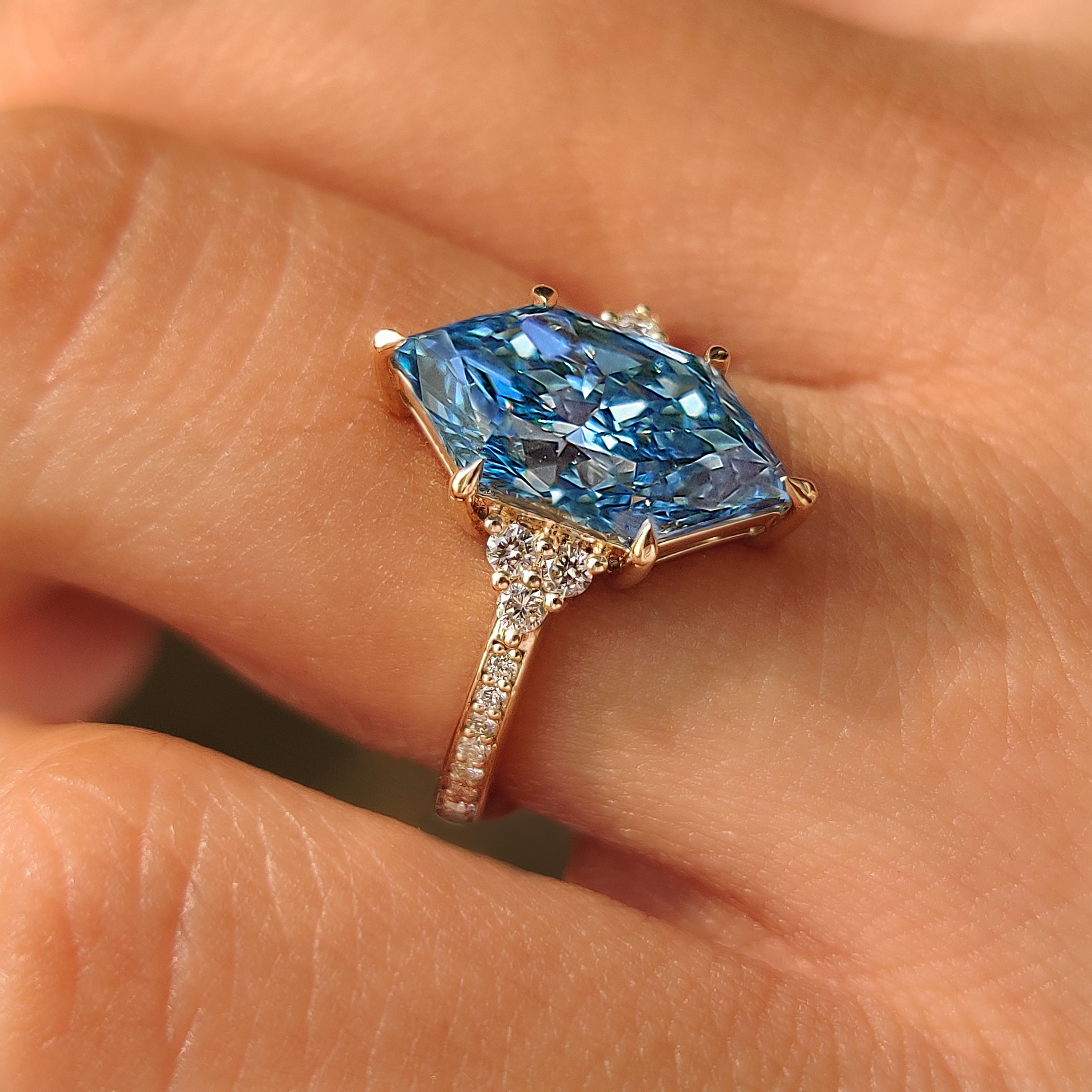 Blue Dutch marquise ring with a round diamond cluster setting.
