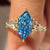 Nature inspired engagement ring with blue marquise center diamond
