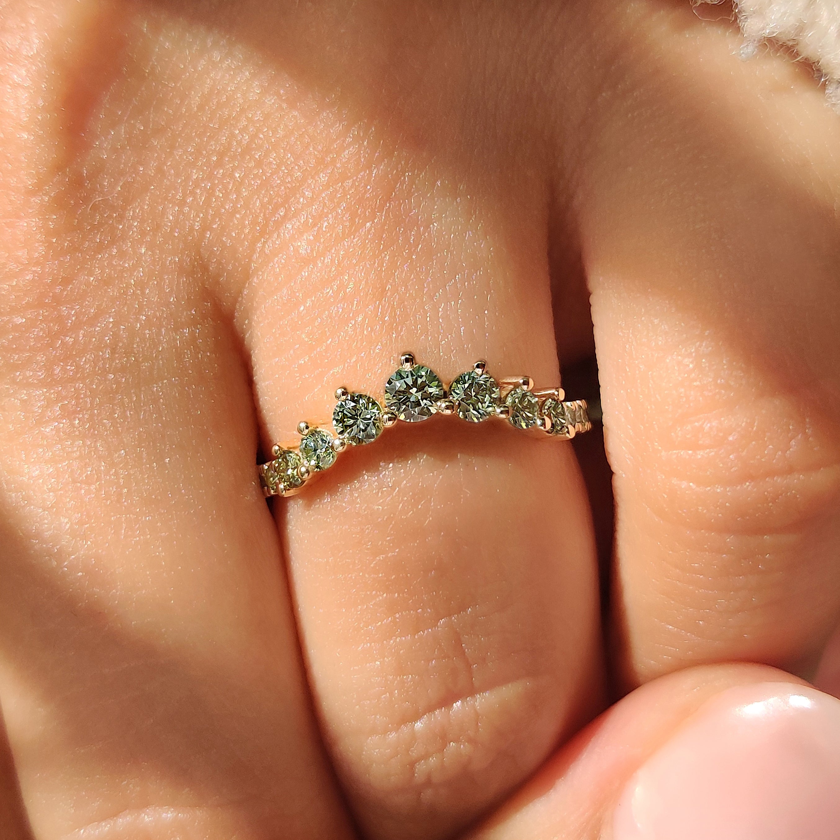 Green diamond wedding band with chevron style and prongs
