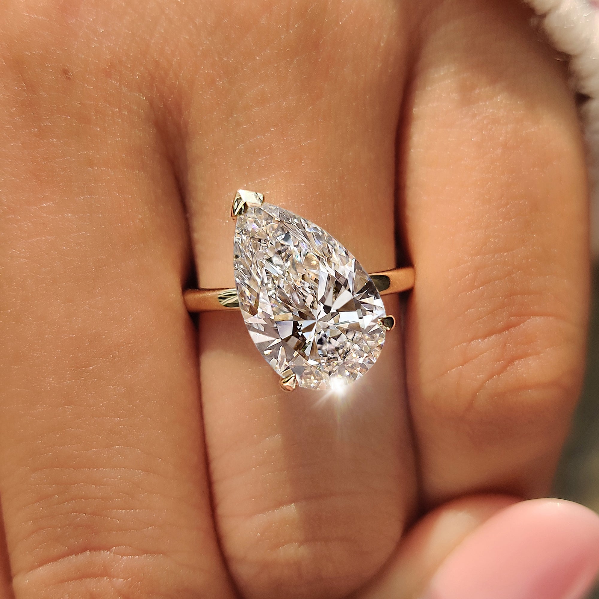 V prong securing the pointed tip of a pear cut diamond ring.
