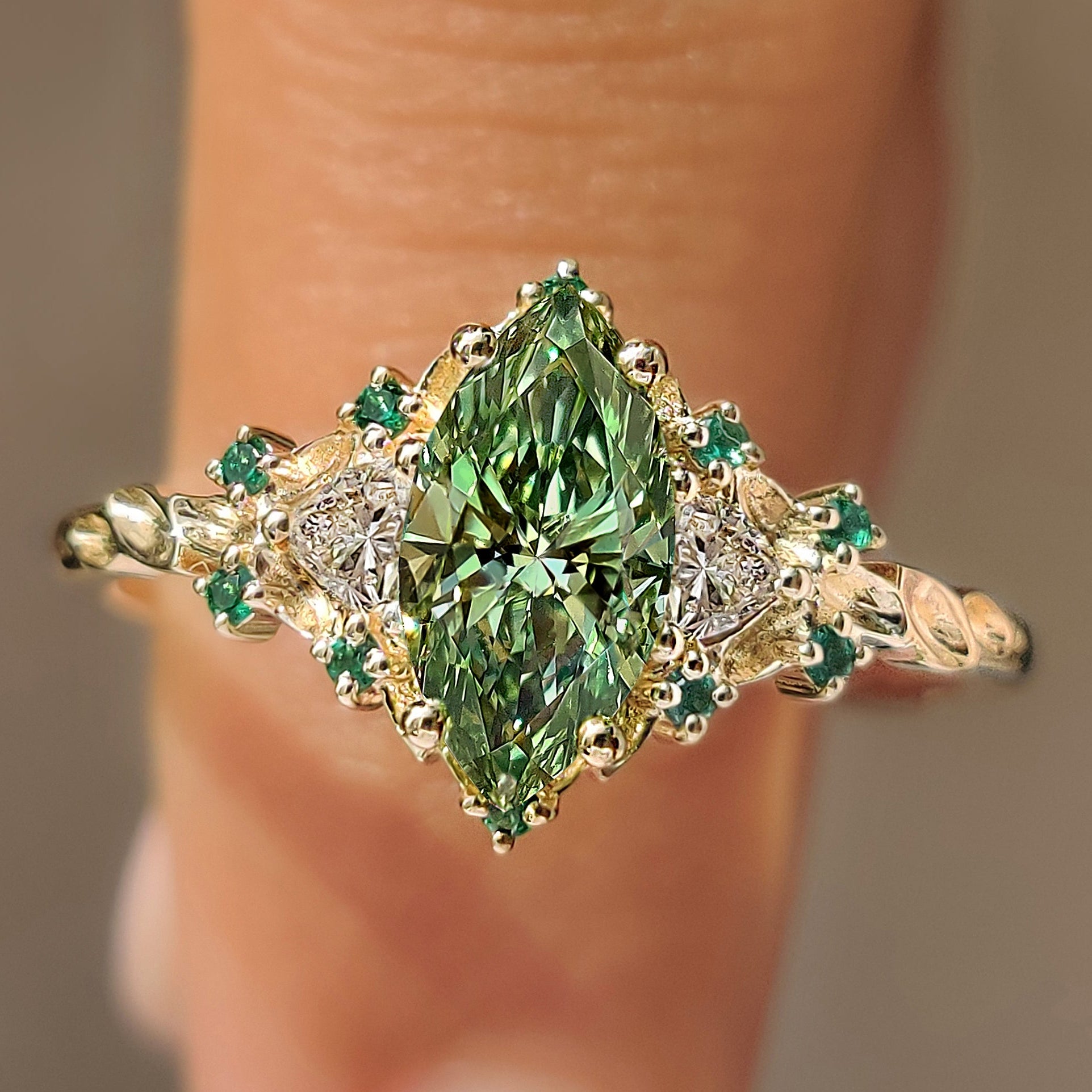 Green marquise cluster ring with trillion side stones.
