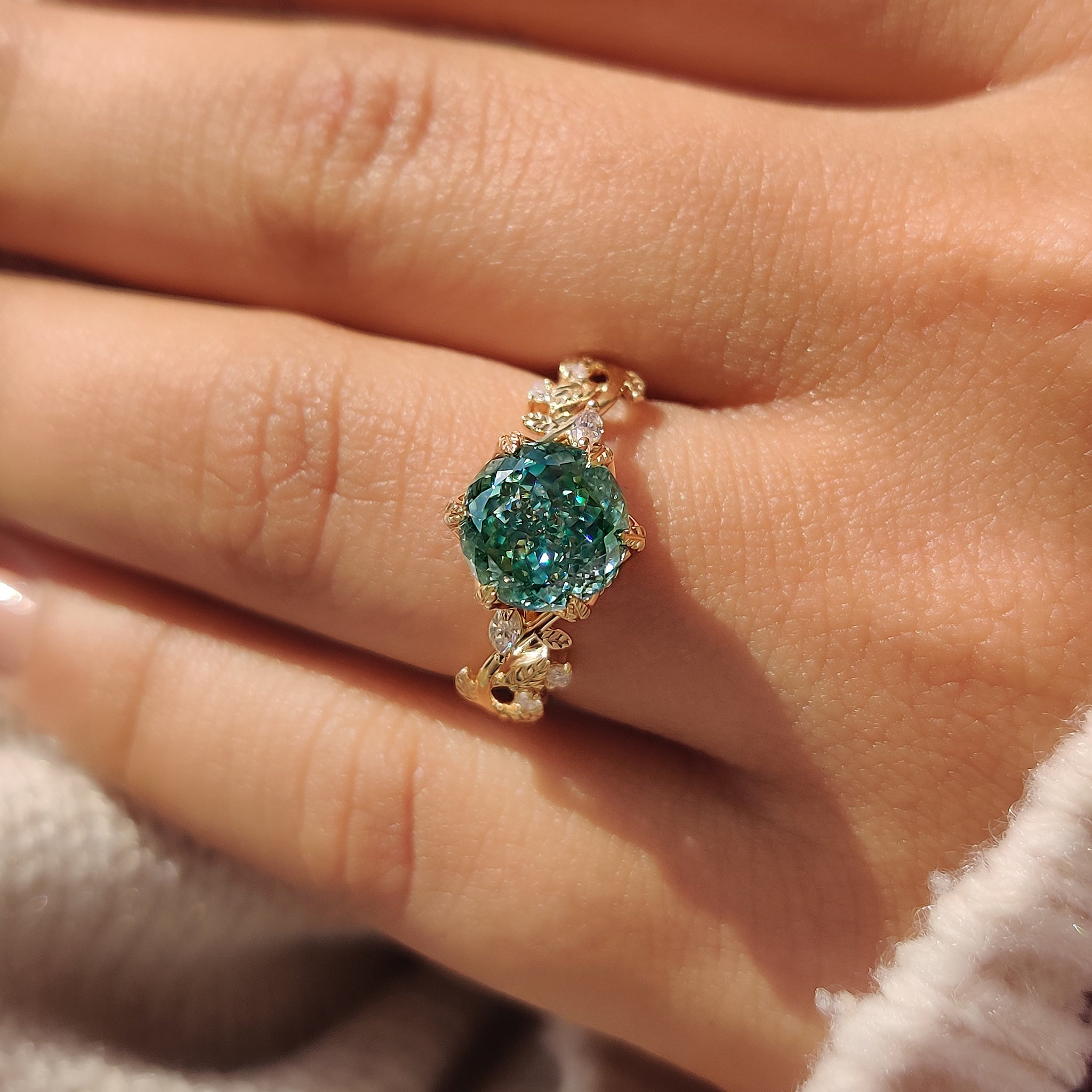 Portuguese cut moissanite ring with cyan blue center stone.
