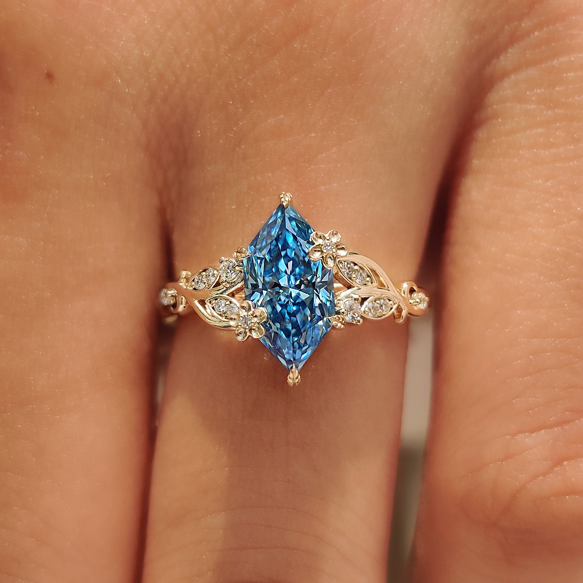 Round diamond side stones on a blue Dutch marquise engagement ring.
