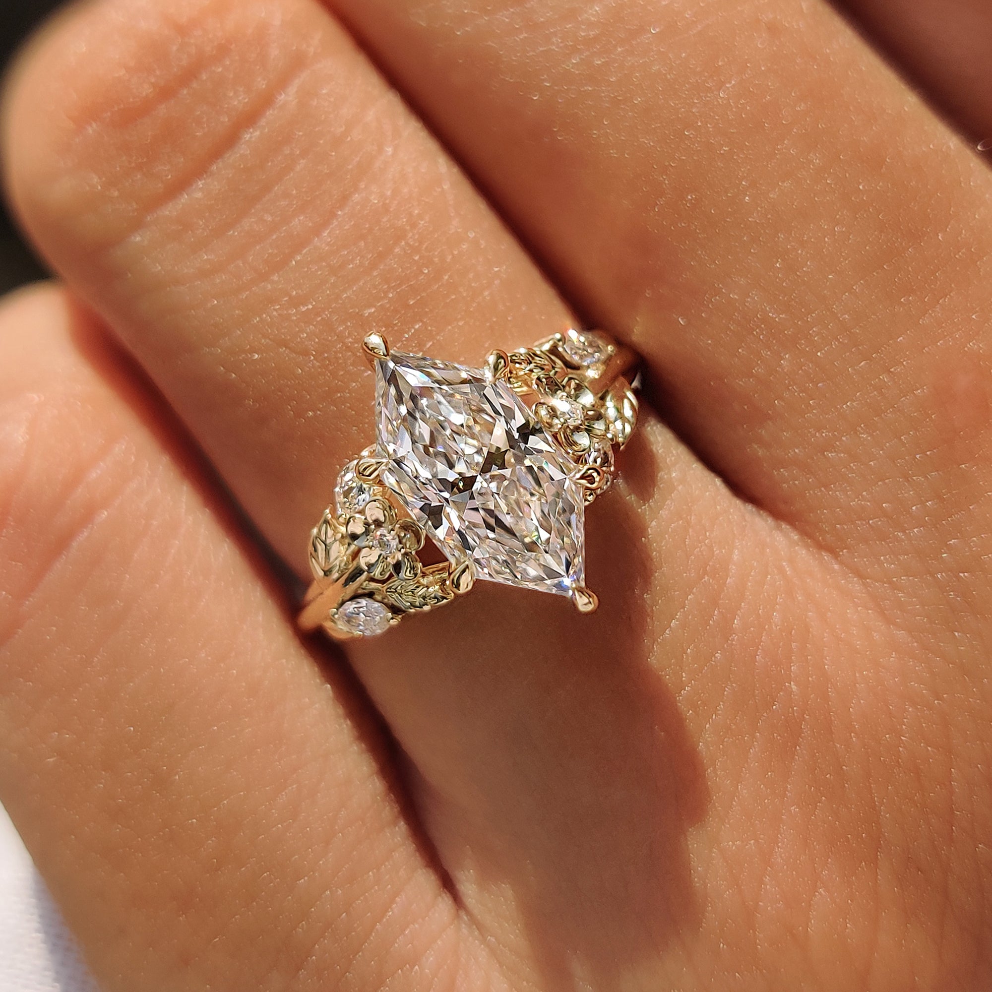 Handmade engagement ring with leaf vine and flower details.
