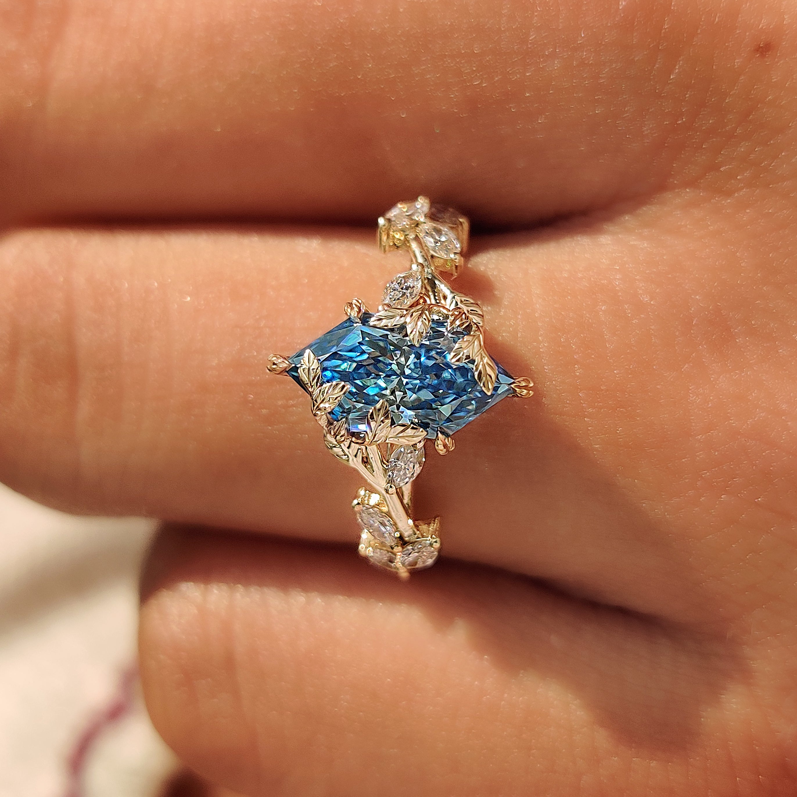 Blue Dutch marquise center diamond held by leaf style prongs.
