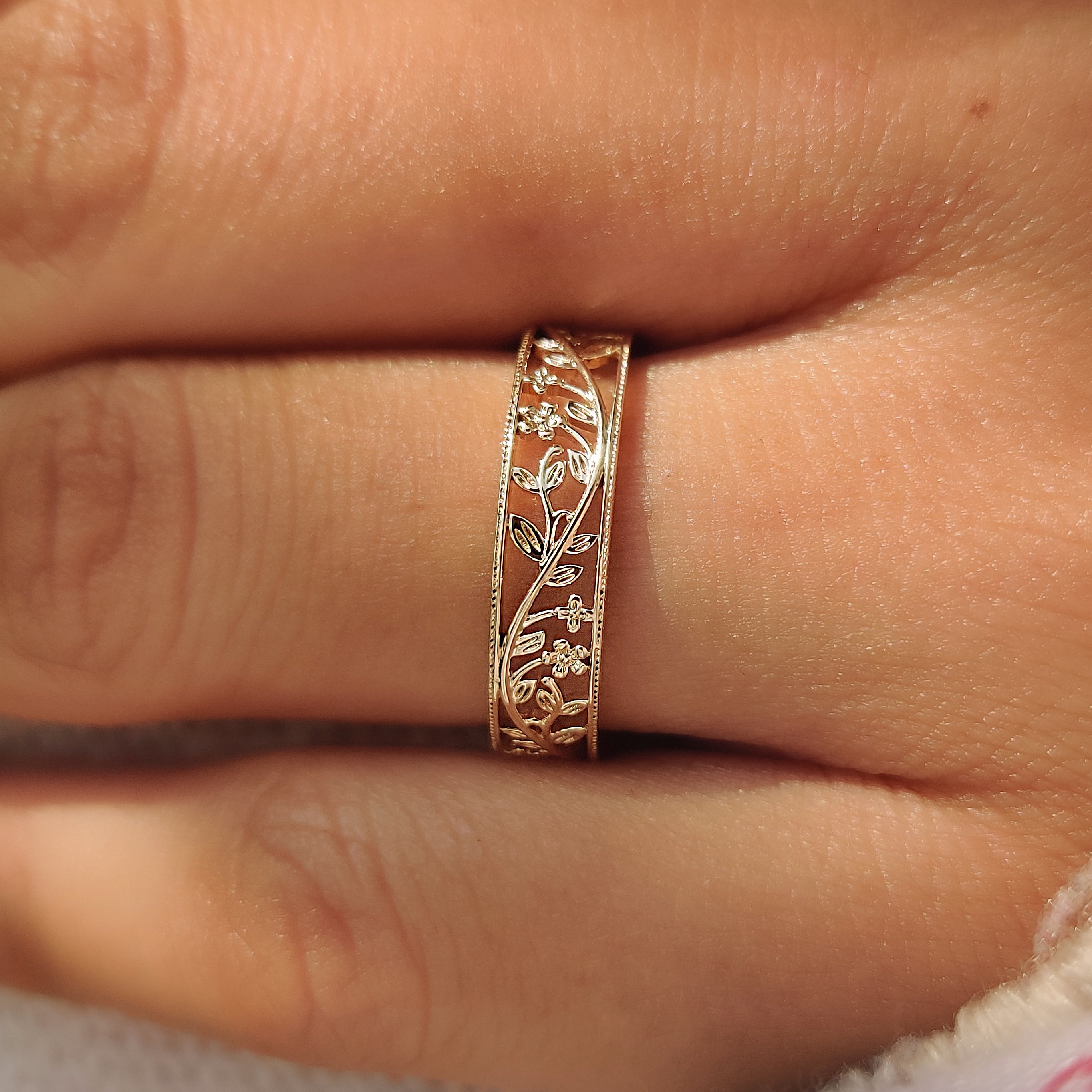Stackable flower wedding band with an openwork design.
