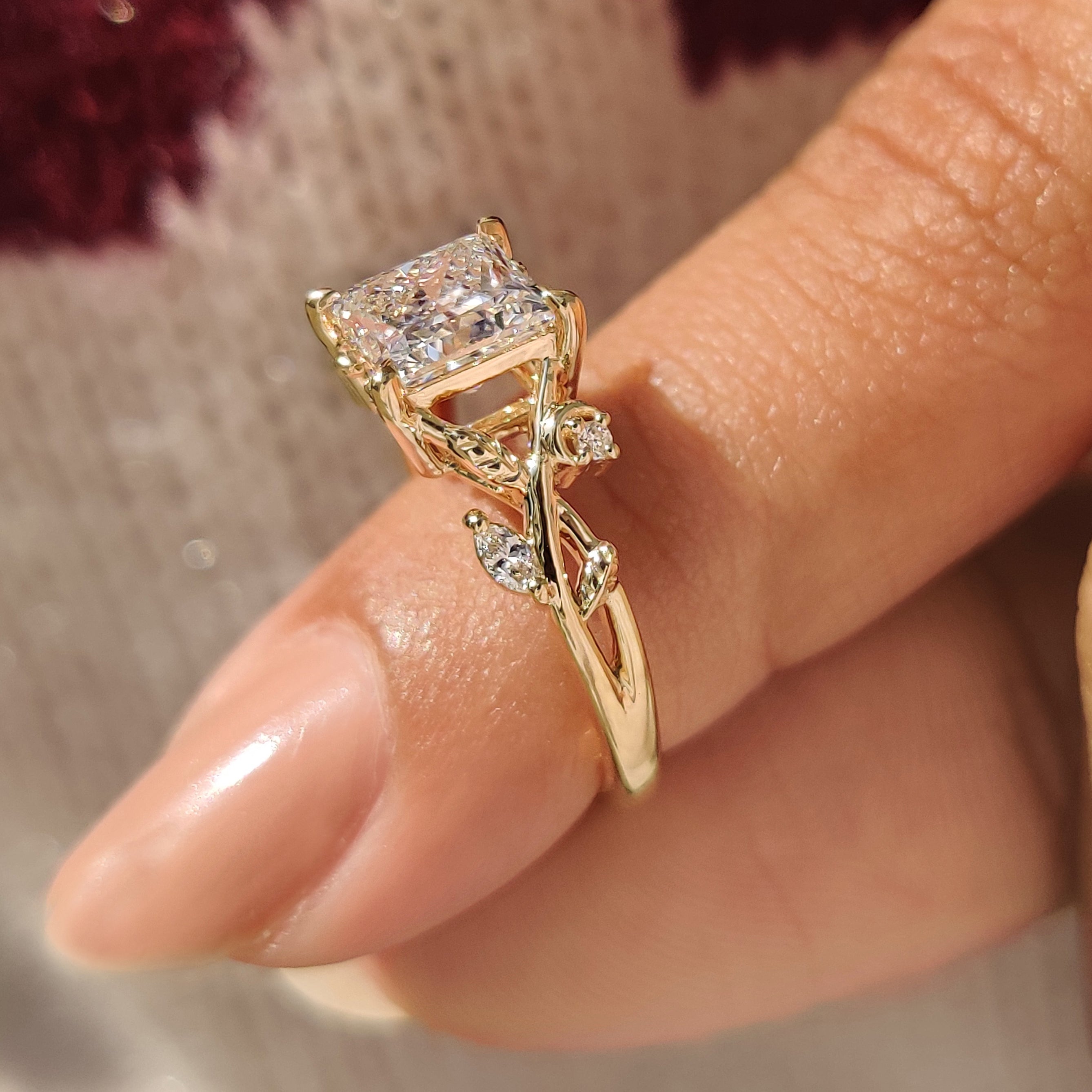 Princess cut ring with petal design and side stones.
