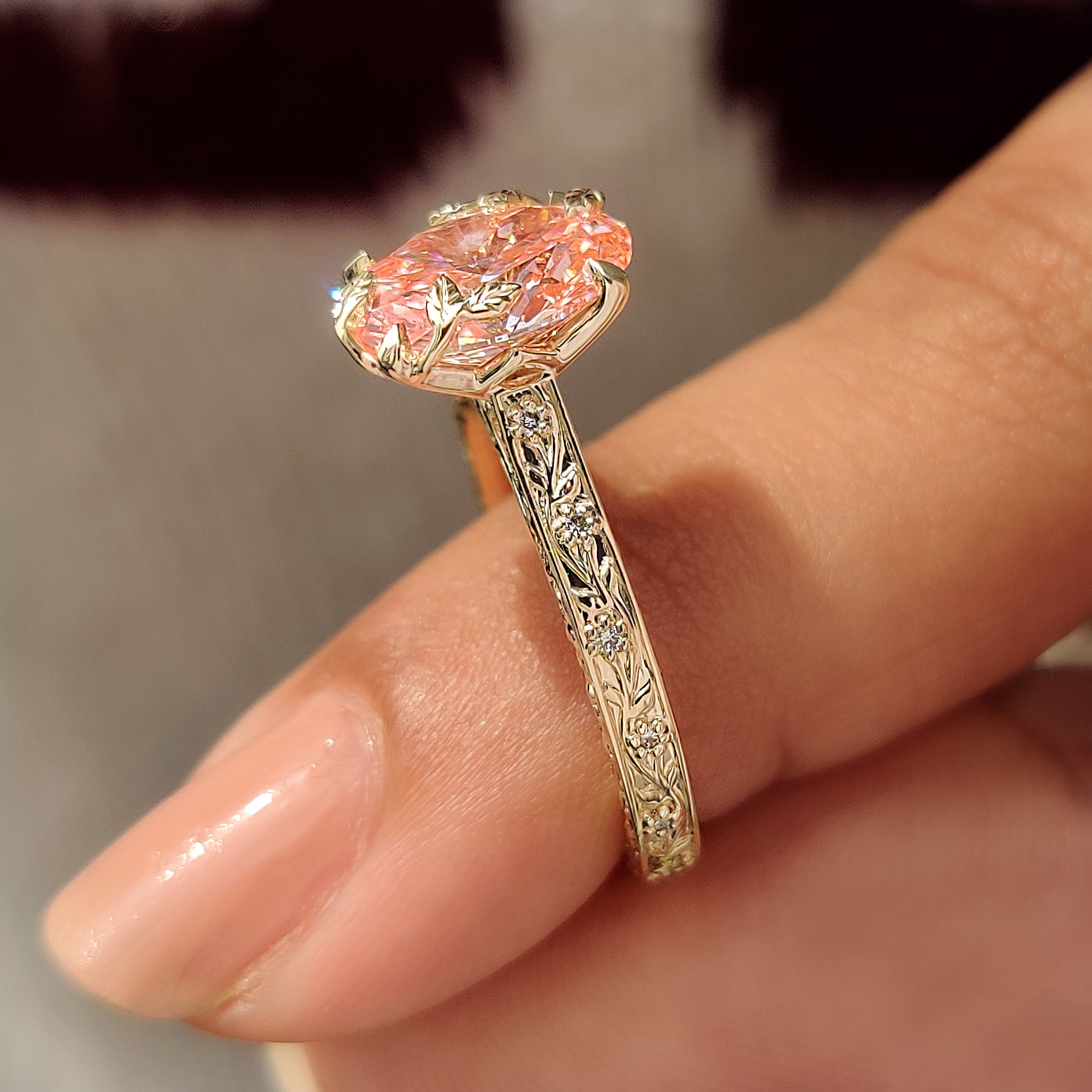 Pink oval diamond ring with leaf and floral details.
