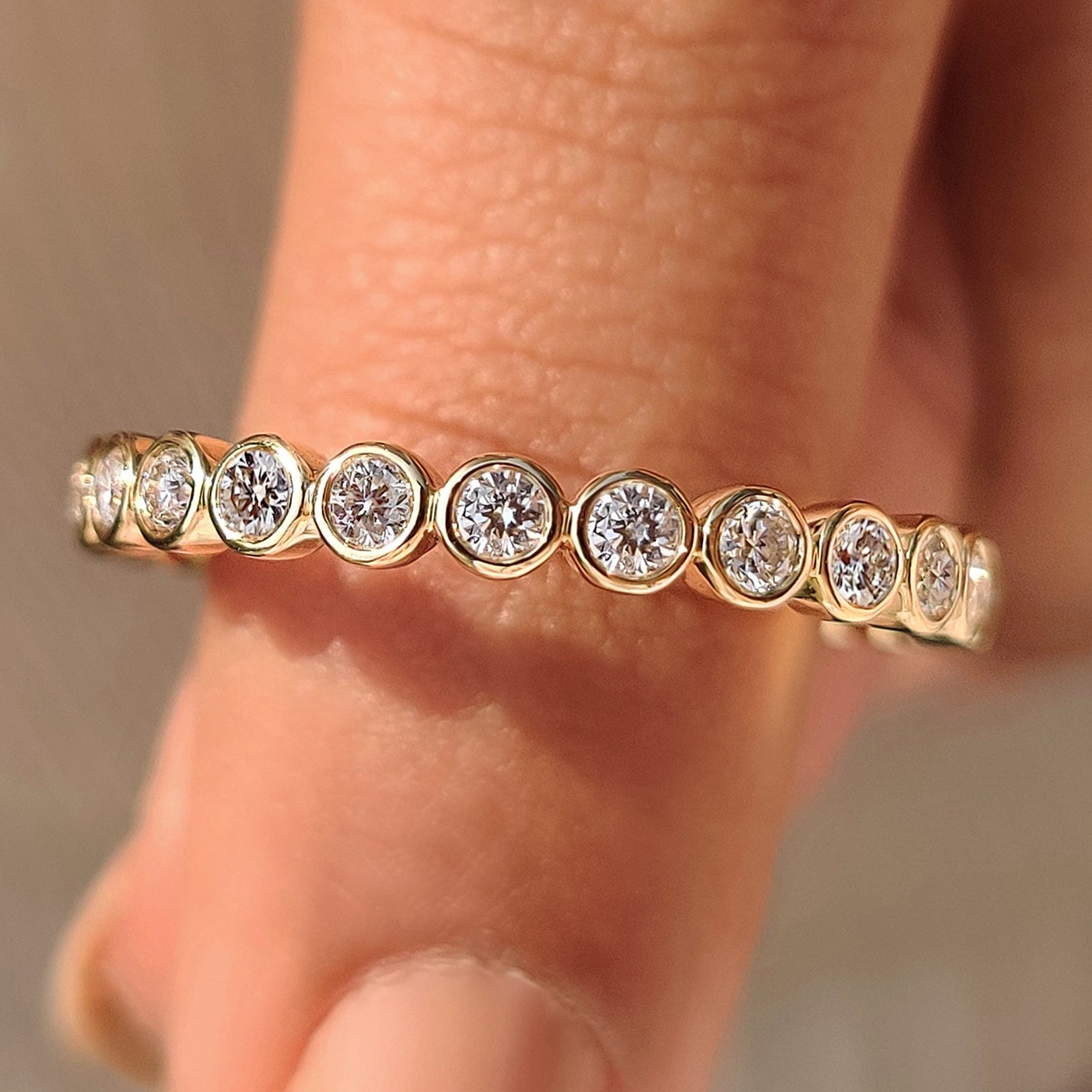Round diamond wedding band with full eternity bezel style.
