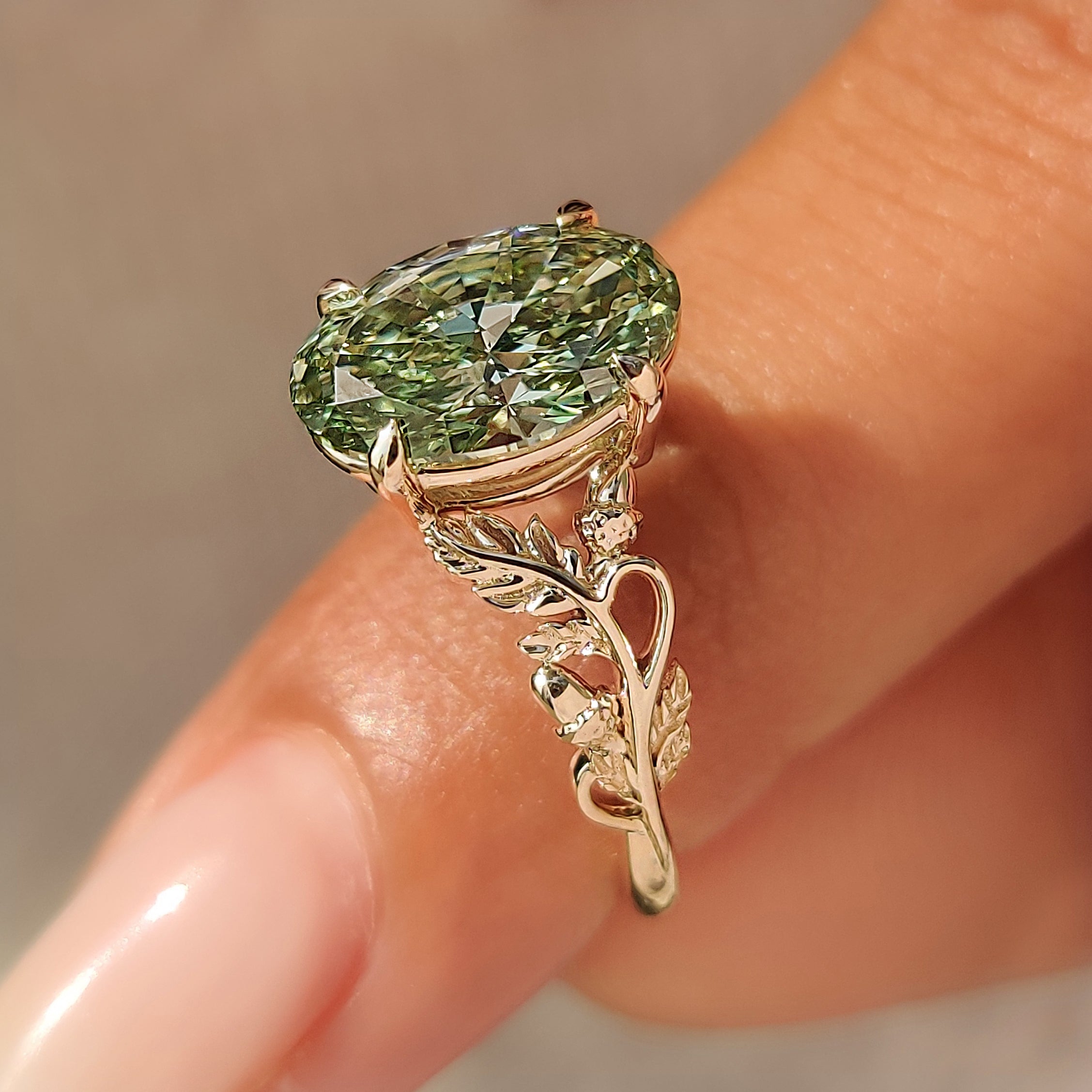 Open gallery basket setting below green oval center diamond.
