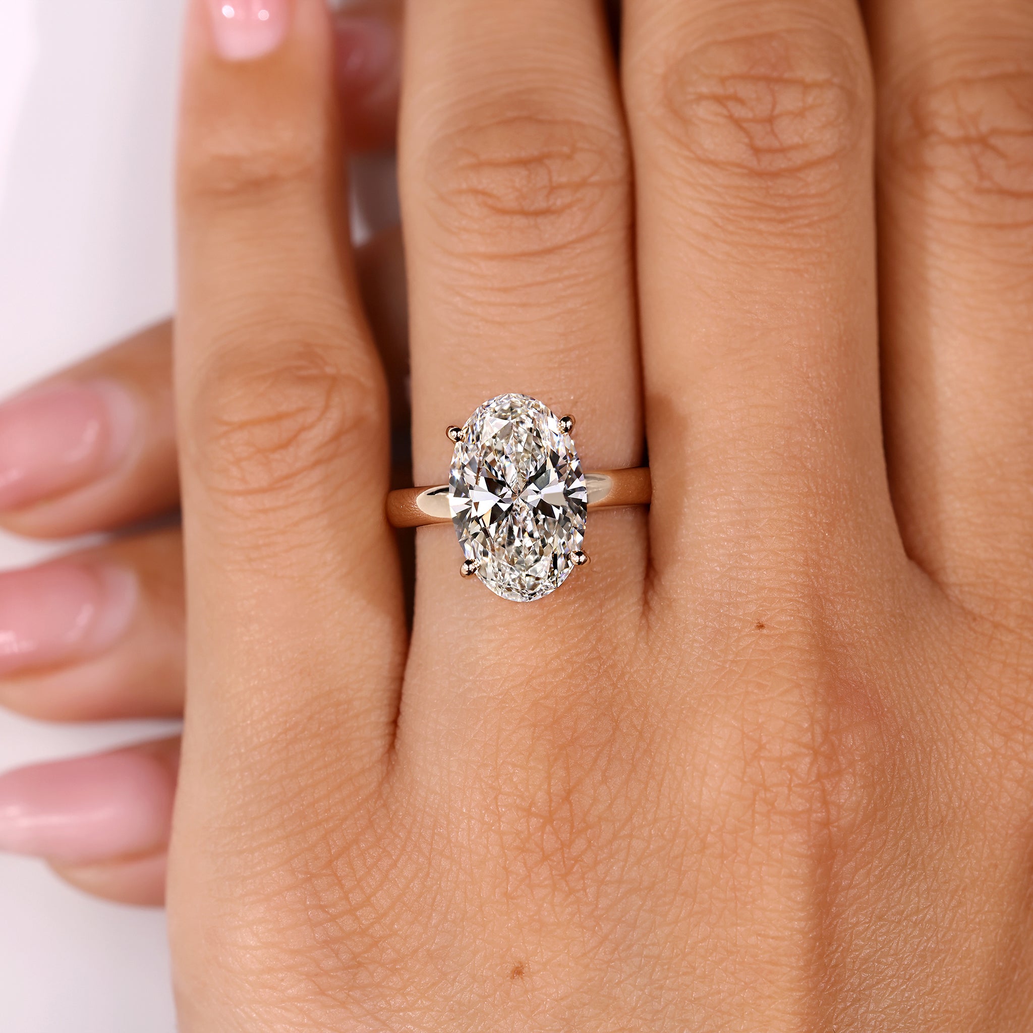Hidden halo engagement ring featuring 5 carat oval diamond
