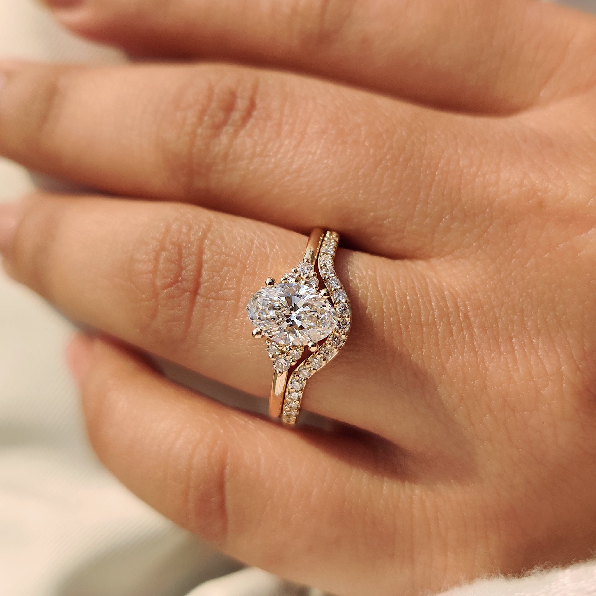 Oval engagement ring with curvy wedding band and diamonds.
