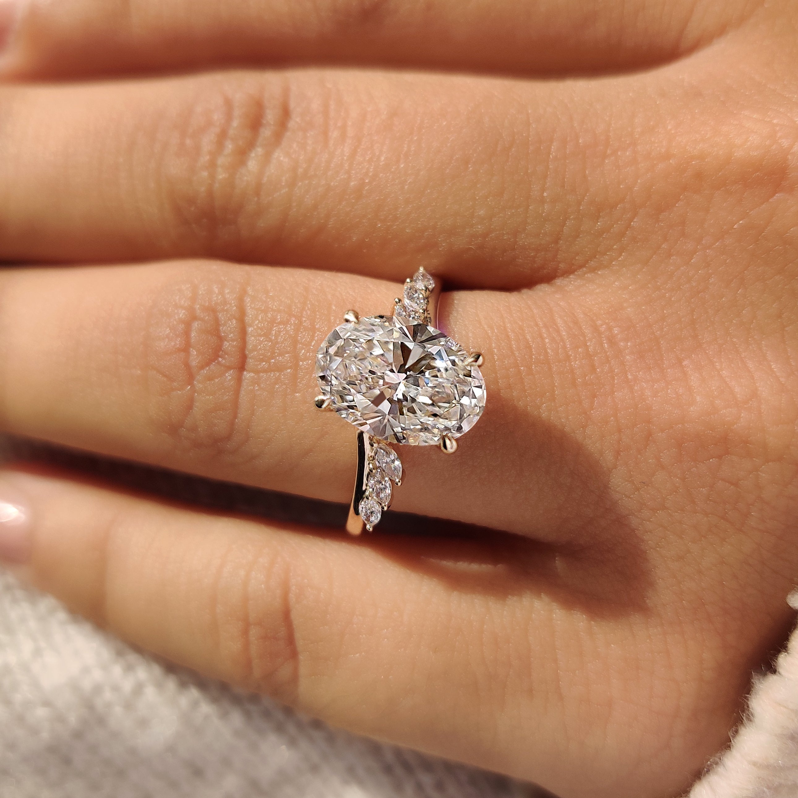 Four claw prong holding oval cut center diamond
