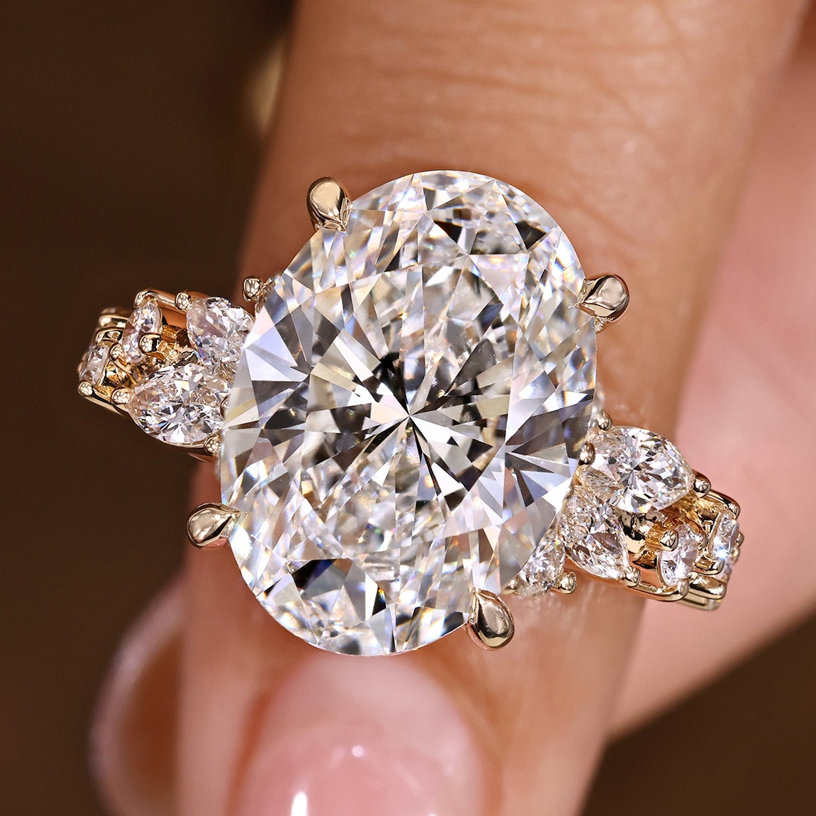 Oval cut diamond ring with marquise and round diamond cluster setting and four claw prong.
