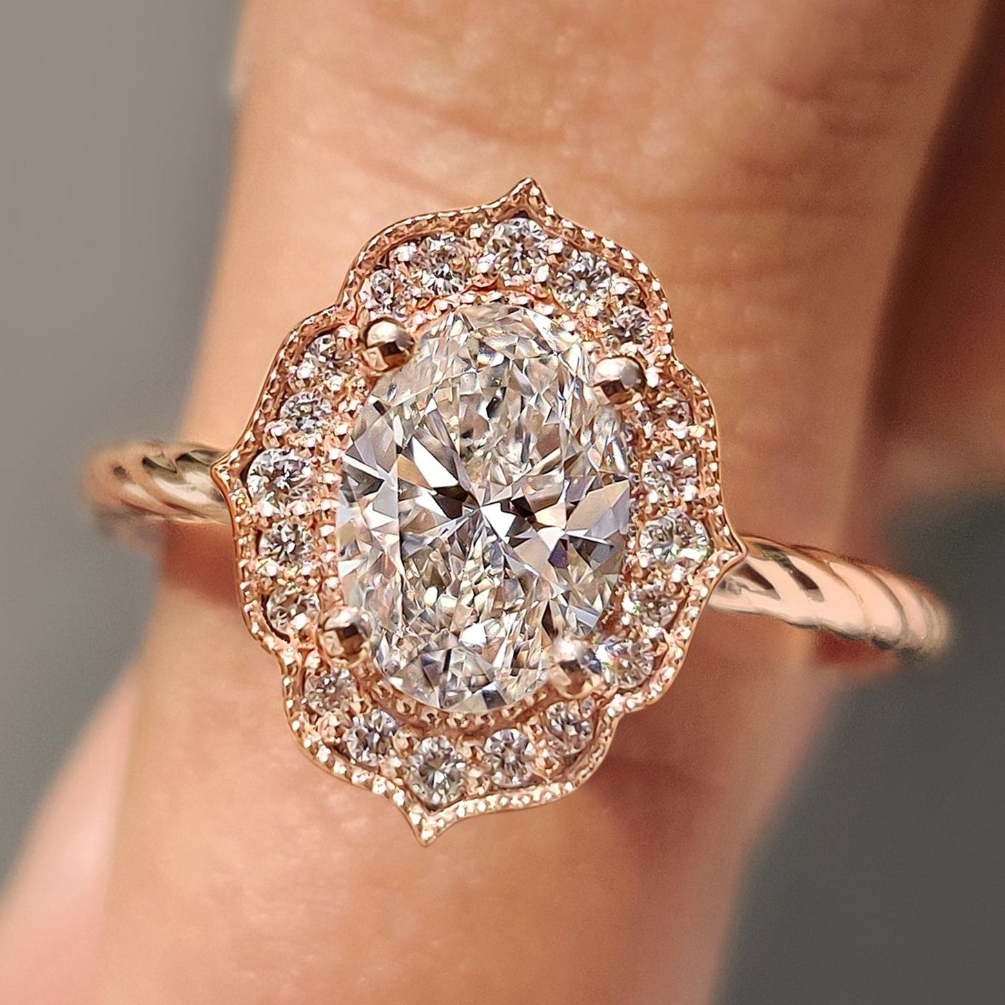 Oval diamond engagement ring with round cut halo setting.
