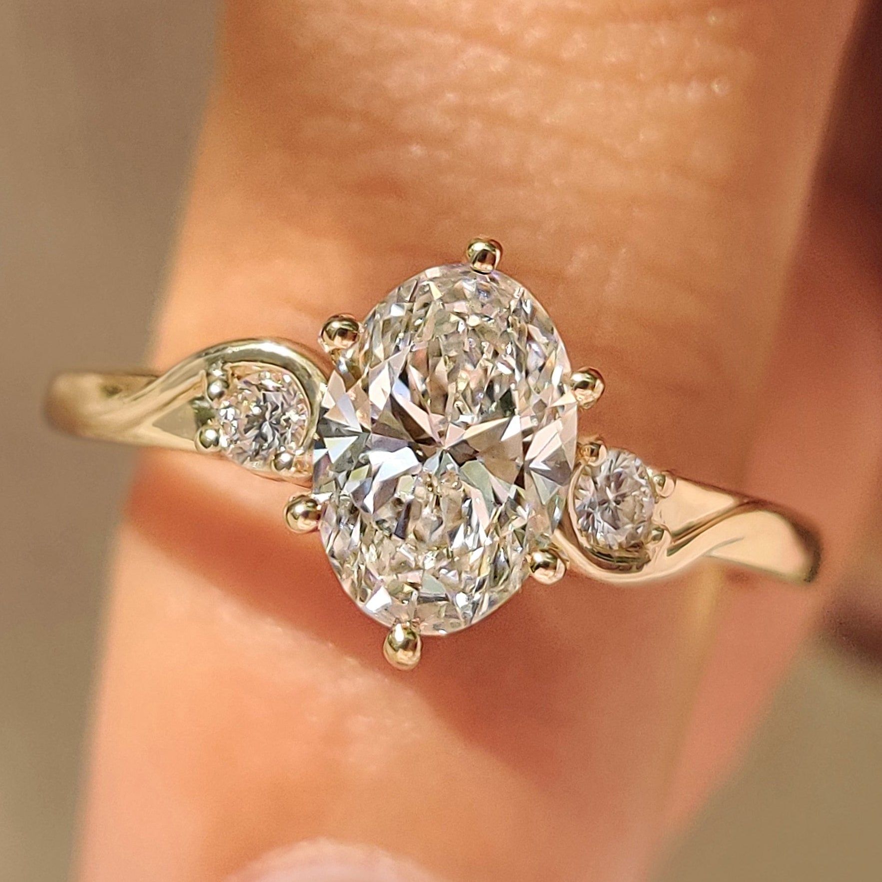 Three Stone Style Oval Cut Engagement Ring with Round Side Stone