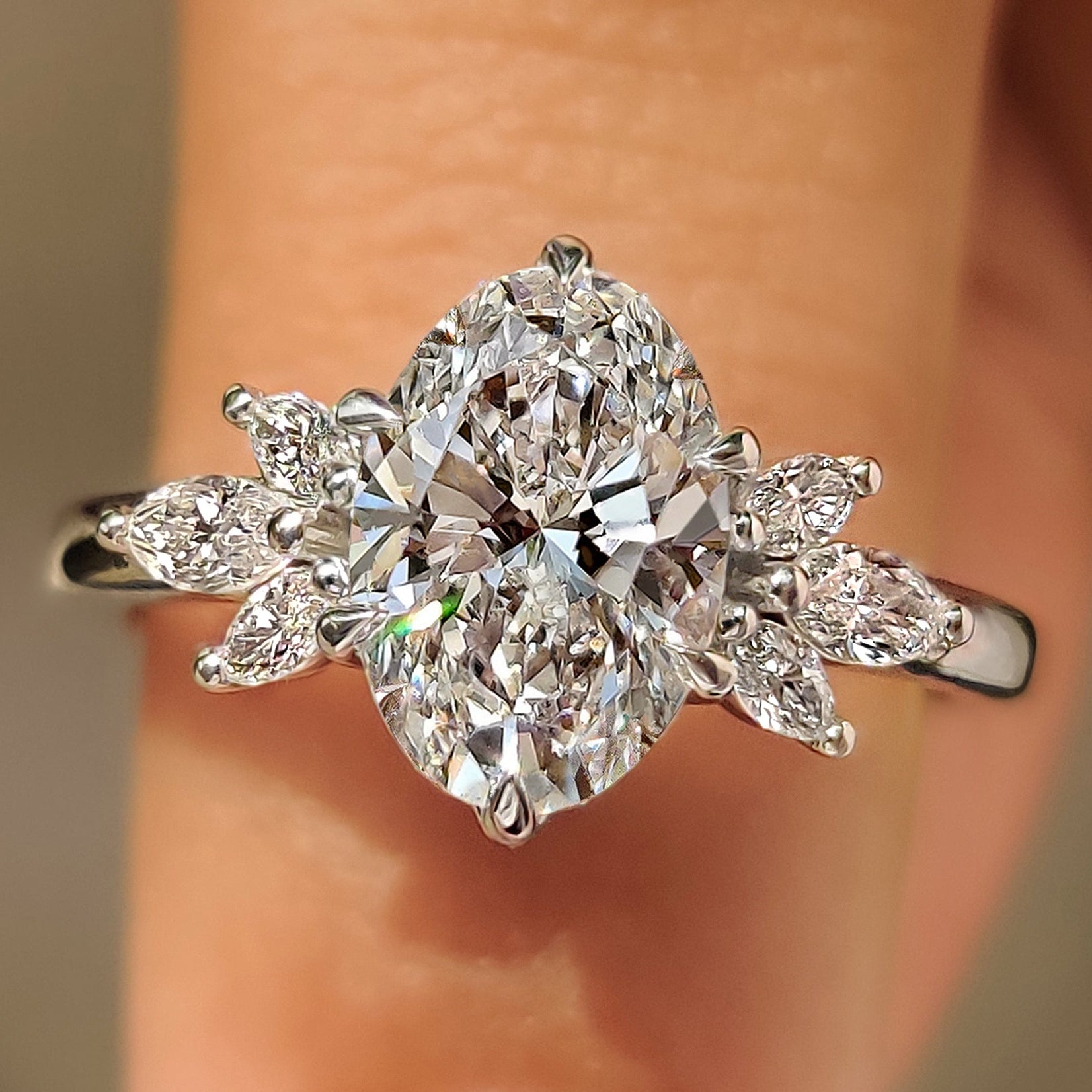 Oval cut diamond ring with marquise side stones design

