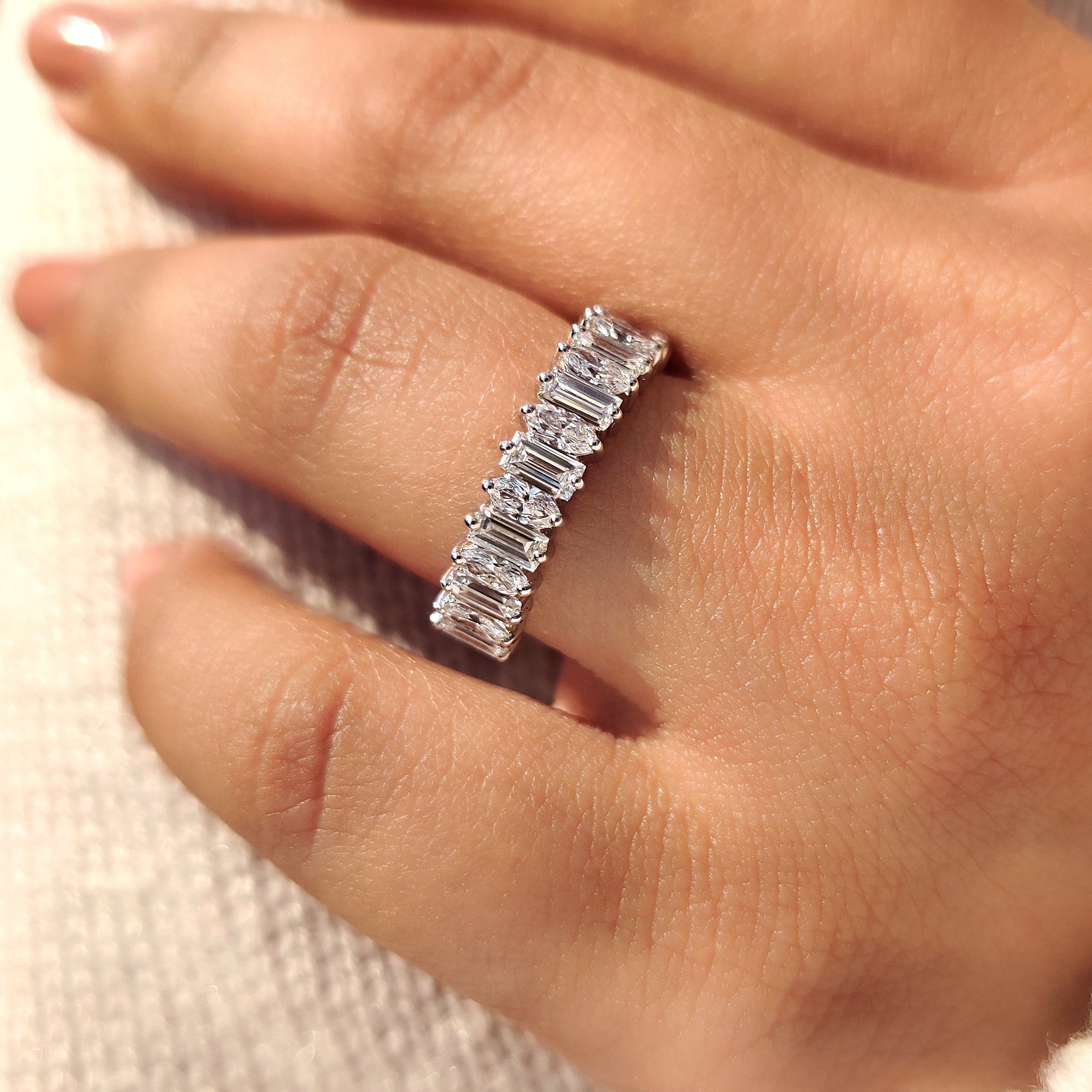 Half eternity band combining baguette and oval diamond shapes
