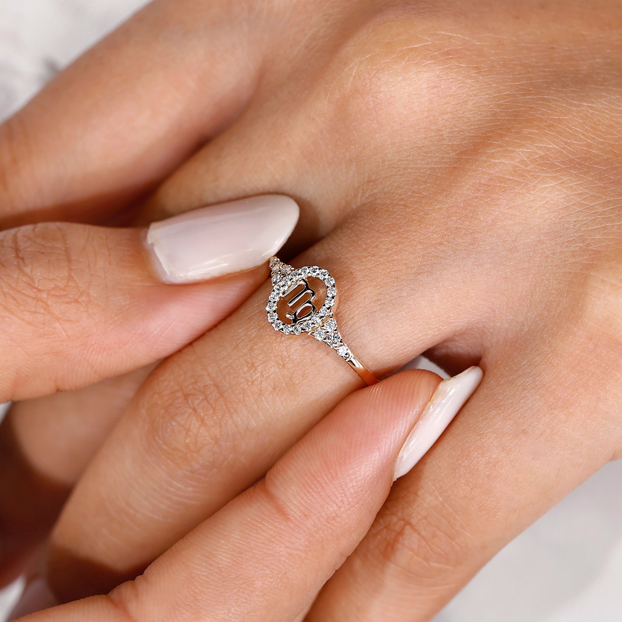 Halo diamond engagement ring in yellow gold with Virgo constellation details.
