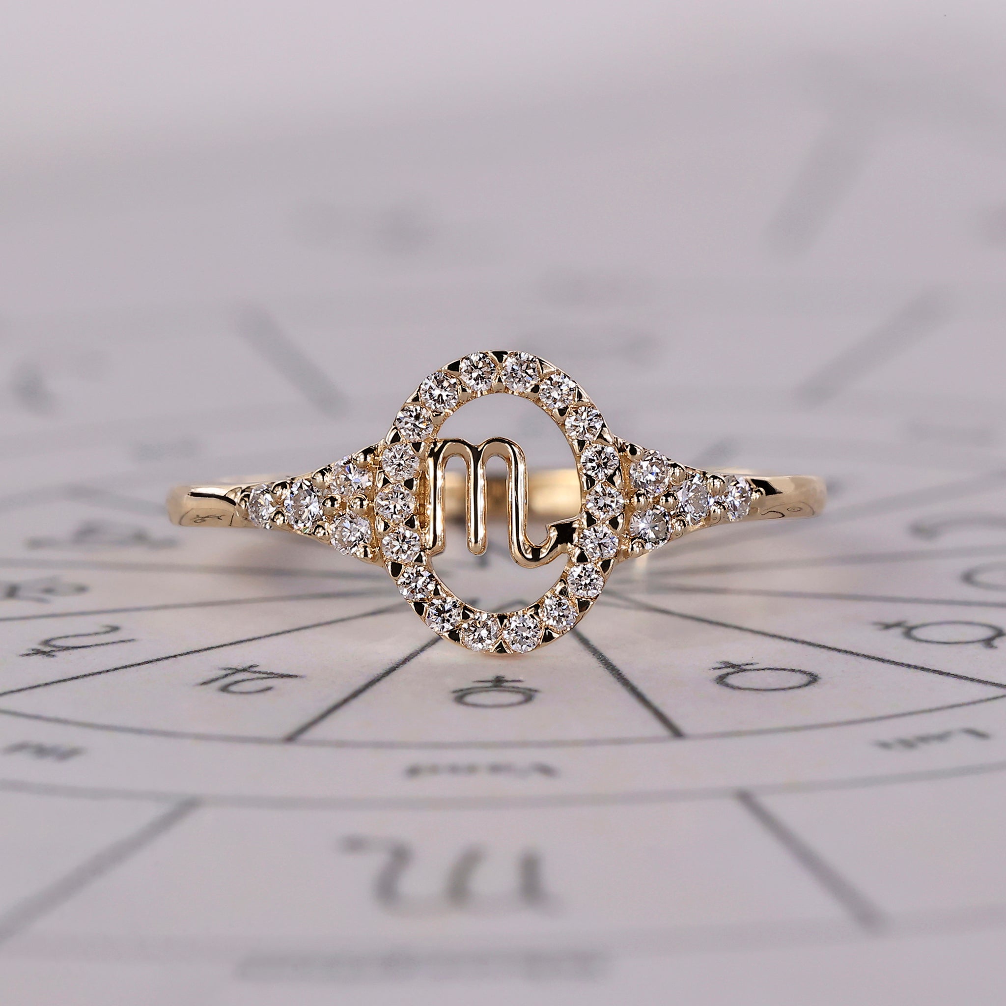 Scorpio ring in yellow gold with halo ring and round cut stones.
