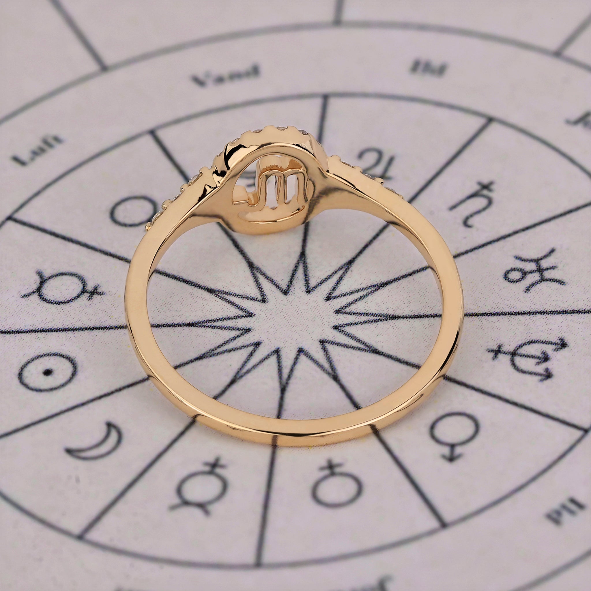 Halo ring in yellow gold with Scorpio constellation and round cut stones.
