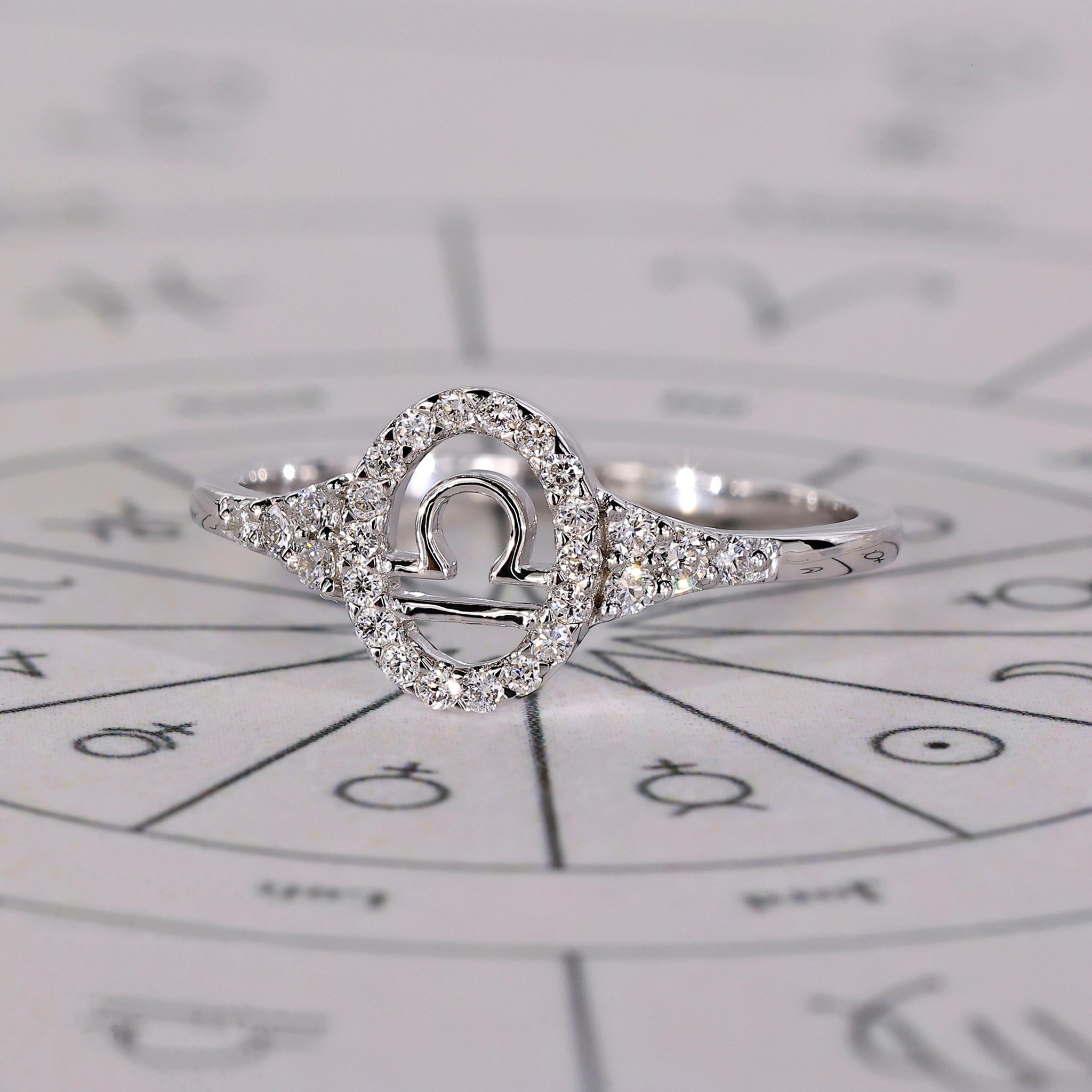 Halo ring in white gold with Libra constellation and round cut stones.
