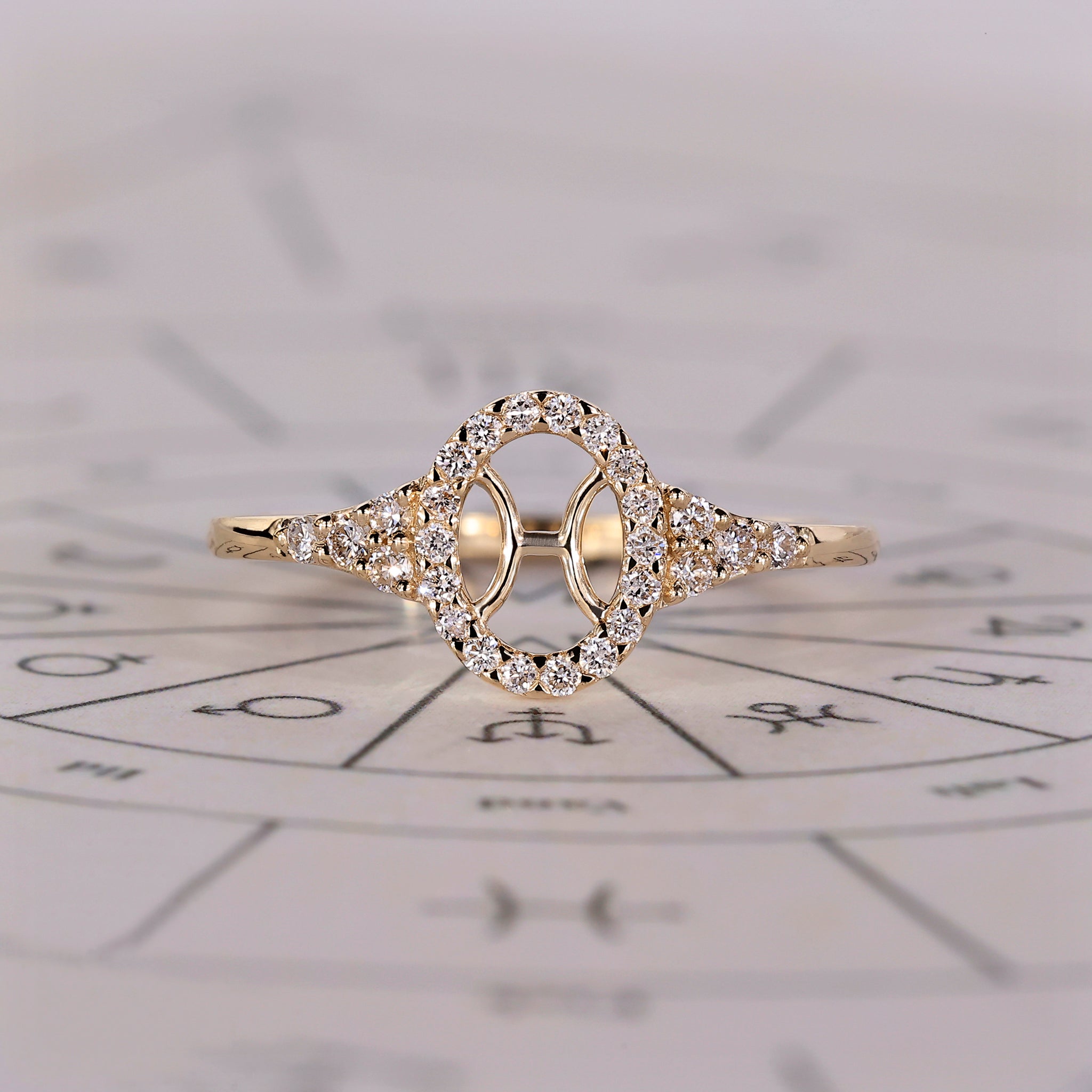 Pisces ring in yellow gold with halo diamond and round side stones.
