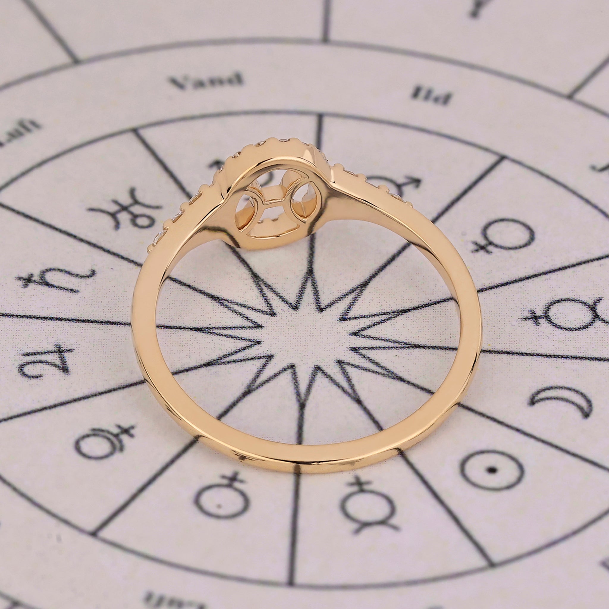 Halo diamond engagement ring in yellow gold with Pisces constellation details.
