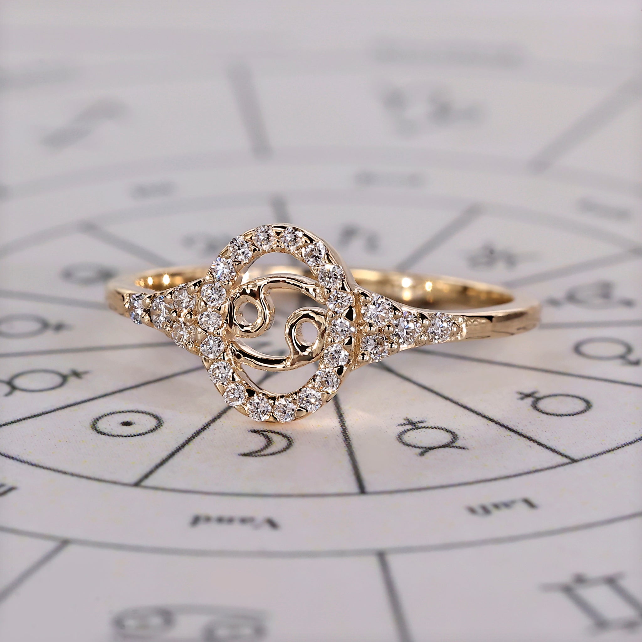 Carat Diamonds Cancer diamond ring with halo engagement design and yellow gold.
