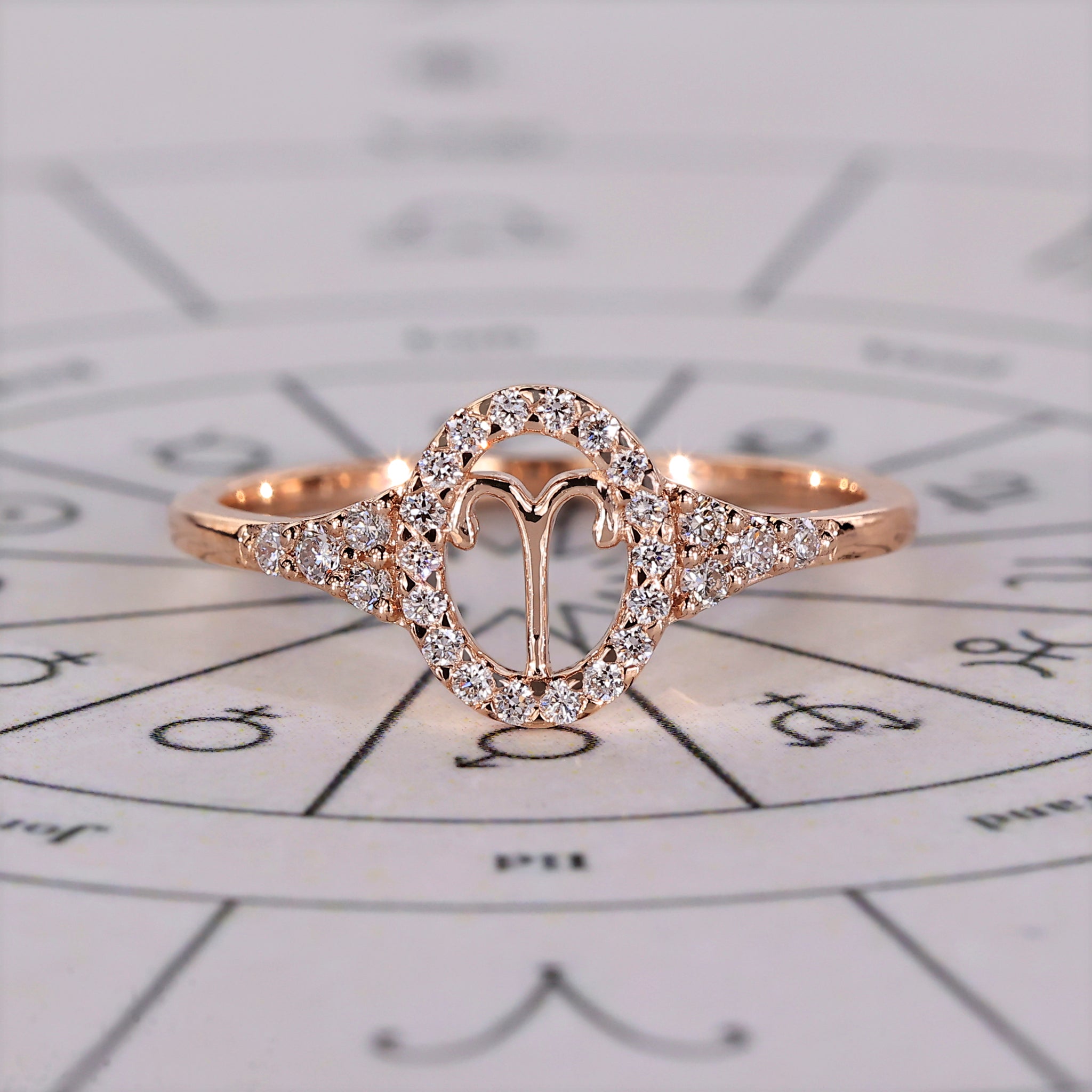 Aries ring in rose gold with halo engagement and round side stones.
