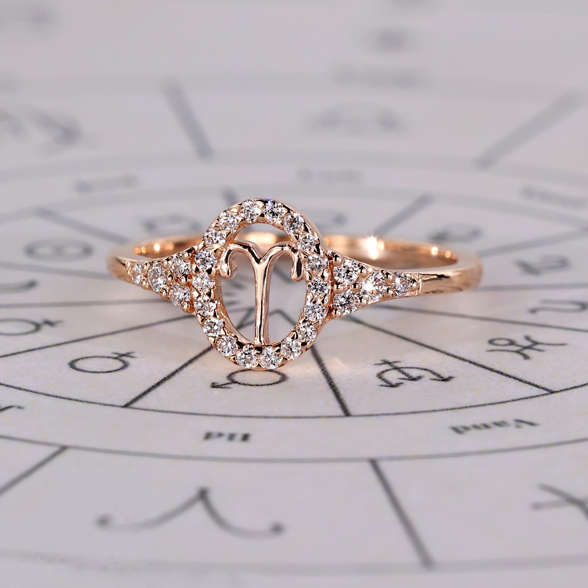 Aries engagement ring in rose gold with round side stones.

