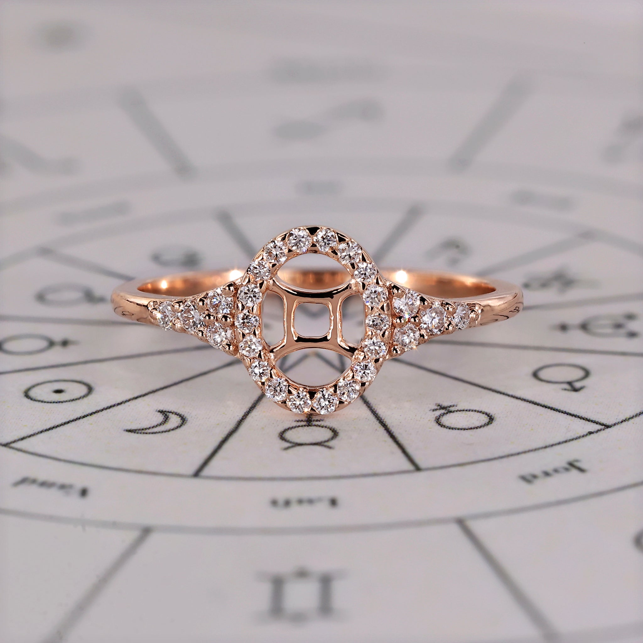 Gemini ring in rose gold with halo diamond and round side stones.
