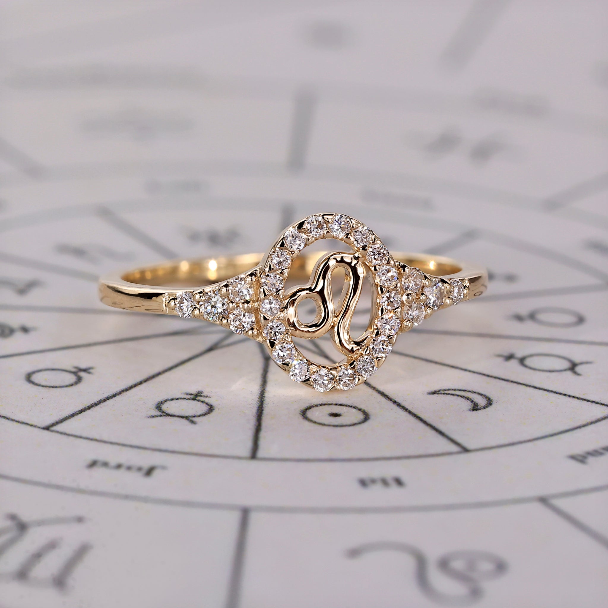Halo diamond engagement ring in yellow gold with Leo constellation design.
