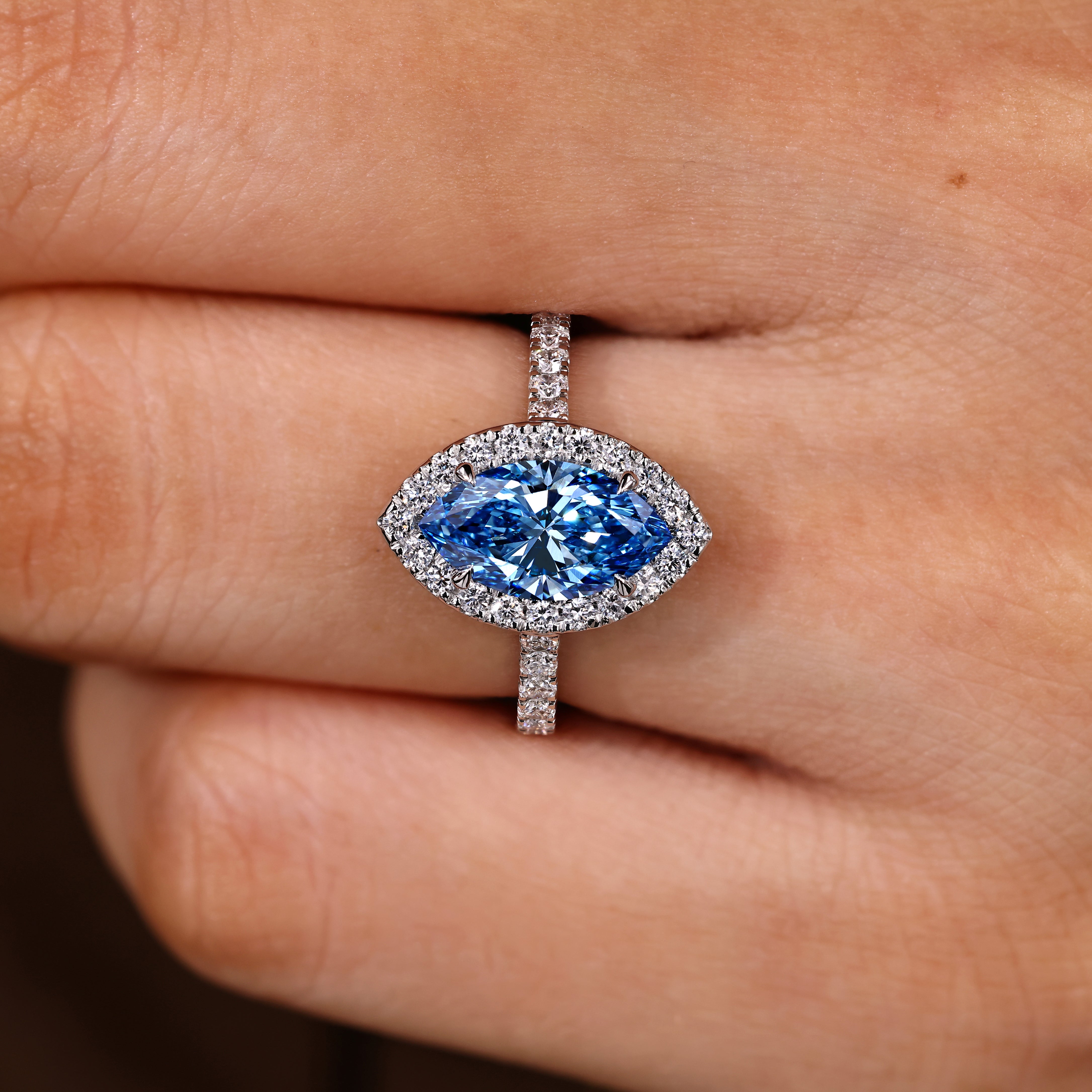 Marquise cut ring with halo and pave round diamonds
