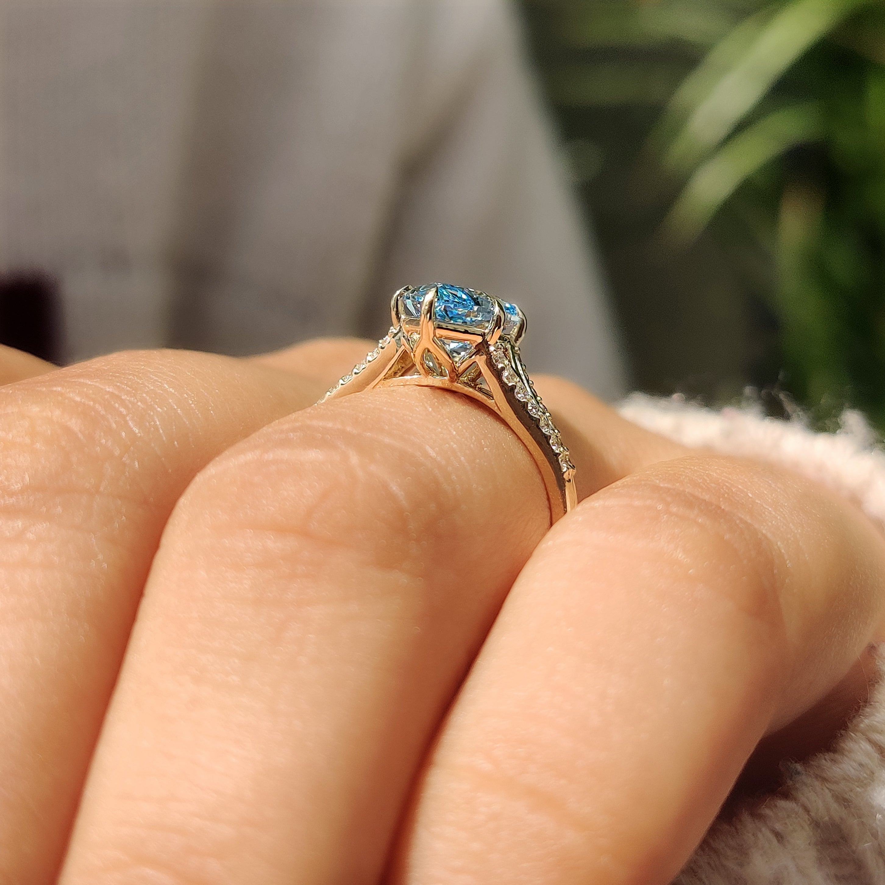 Blue center diamond ring with six claw prong setting
