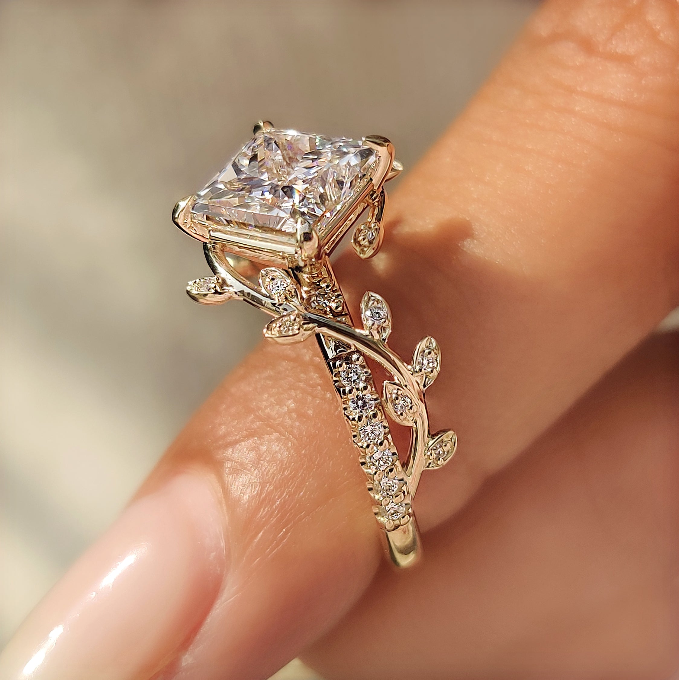 Round pave diamonds surrounding a princess cut center diamond.
