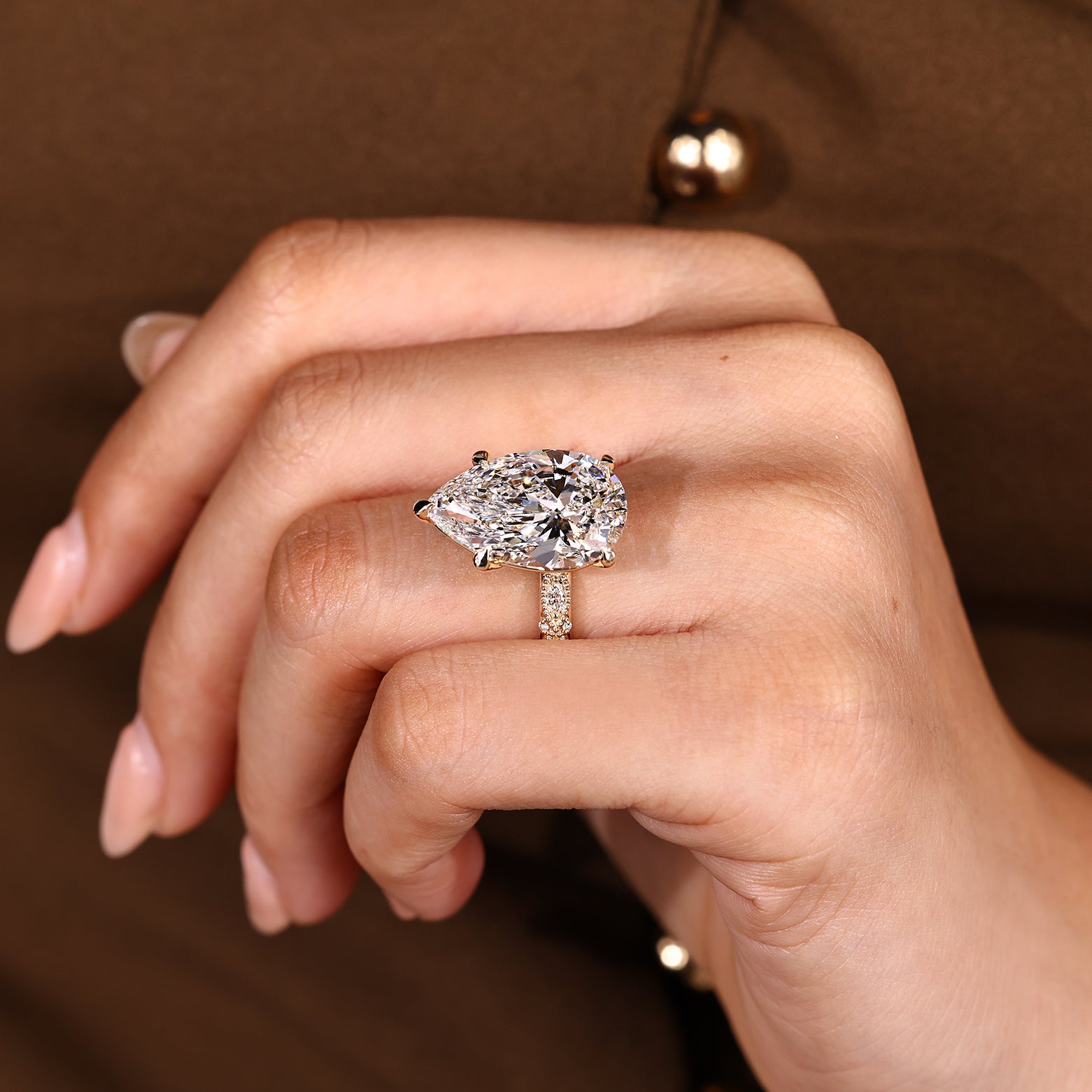 Five claw prong setting holding pear cut center diamond
