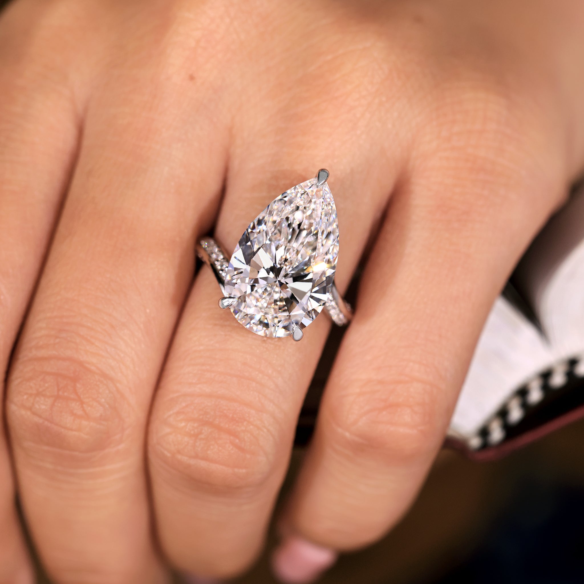 Pear diamond ring in a flowing bypass design with three claw prong support.
