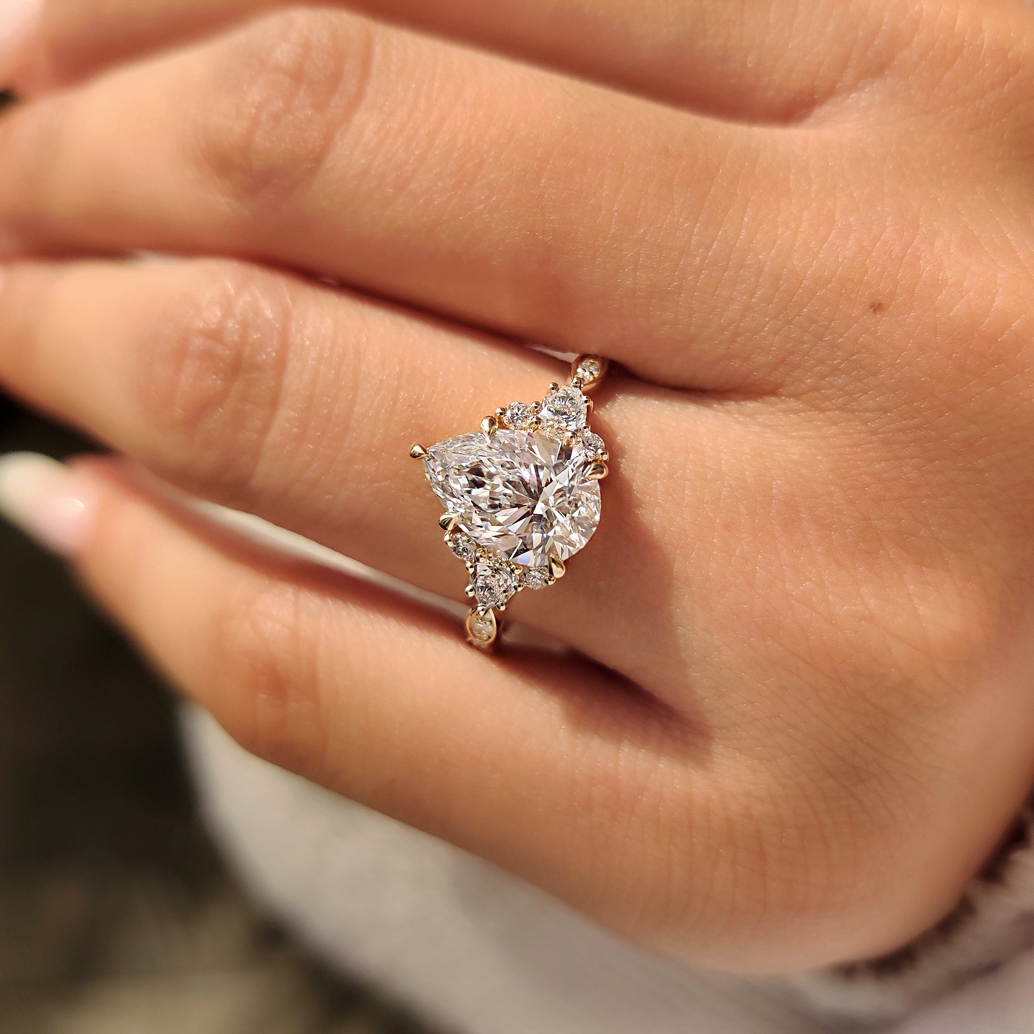 Muse setting pear diamond ring with side stones.
