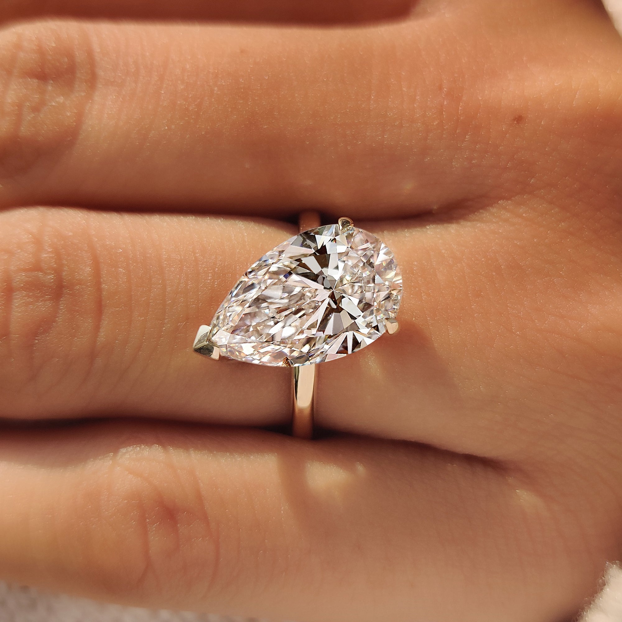 Yellow gold engagement ring with a 5 carat pear cut diamond.
