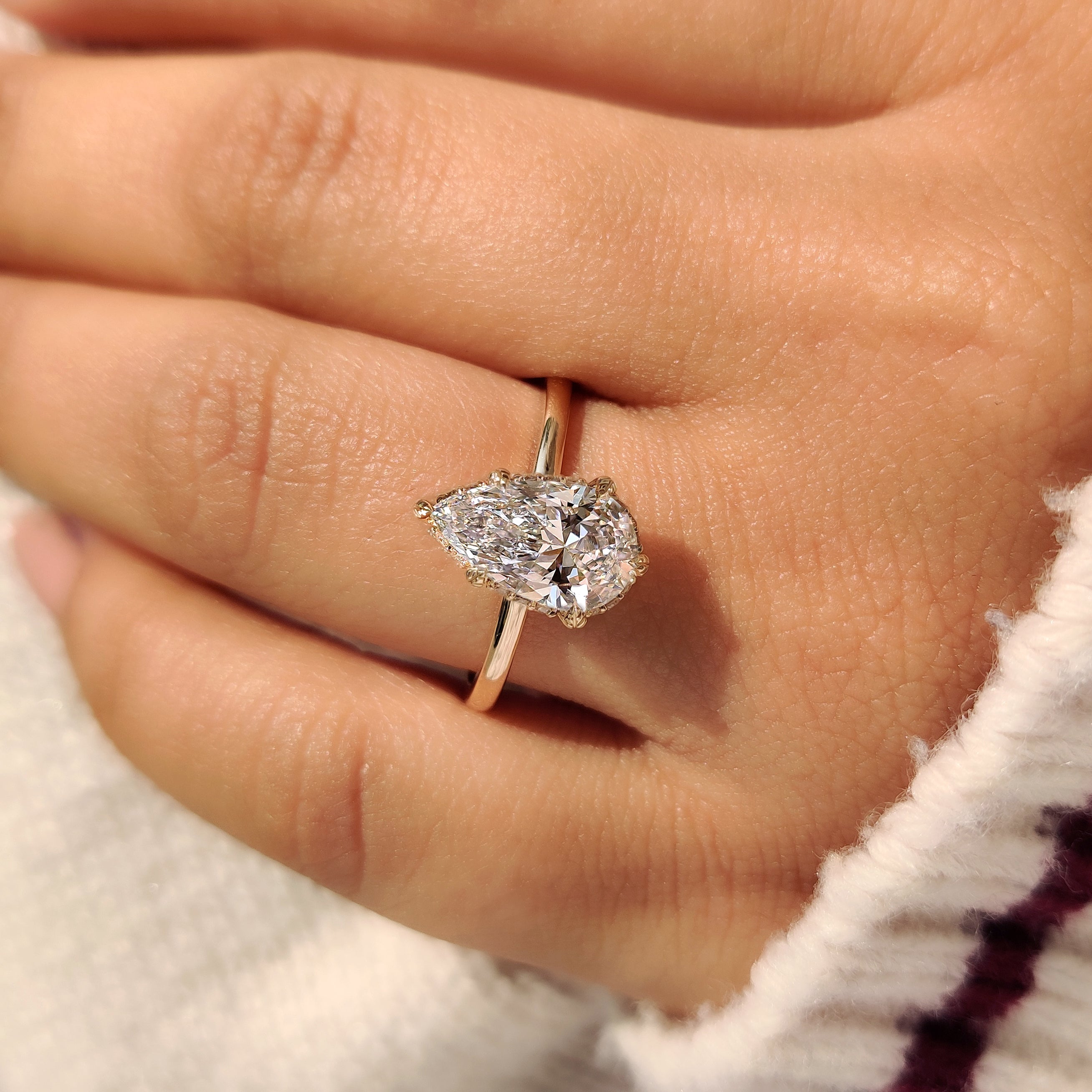 Six prong pear diamond ring with leaf design.
