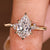 Pear cut engagement ring with marquise and round accents
